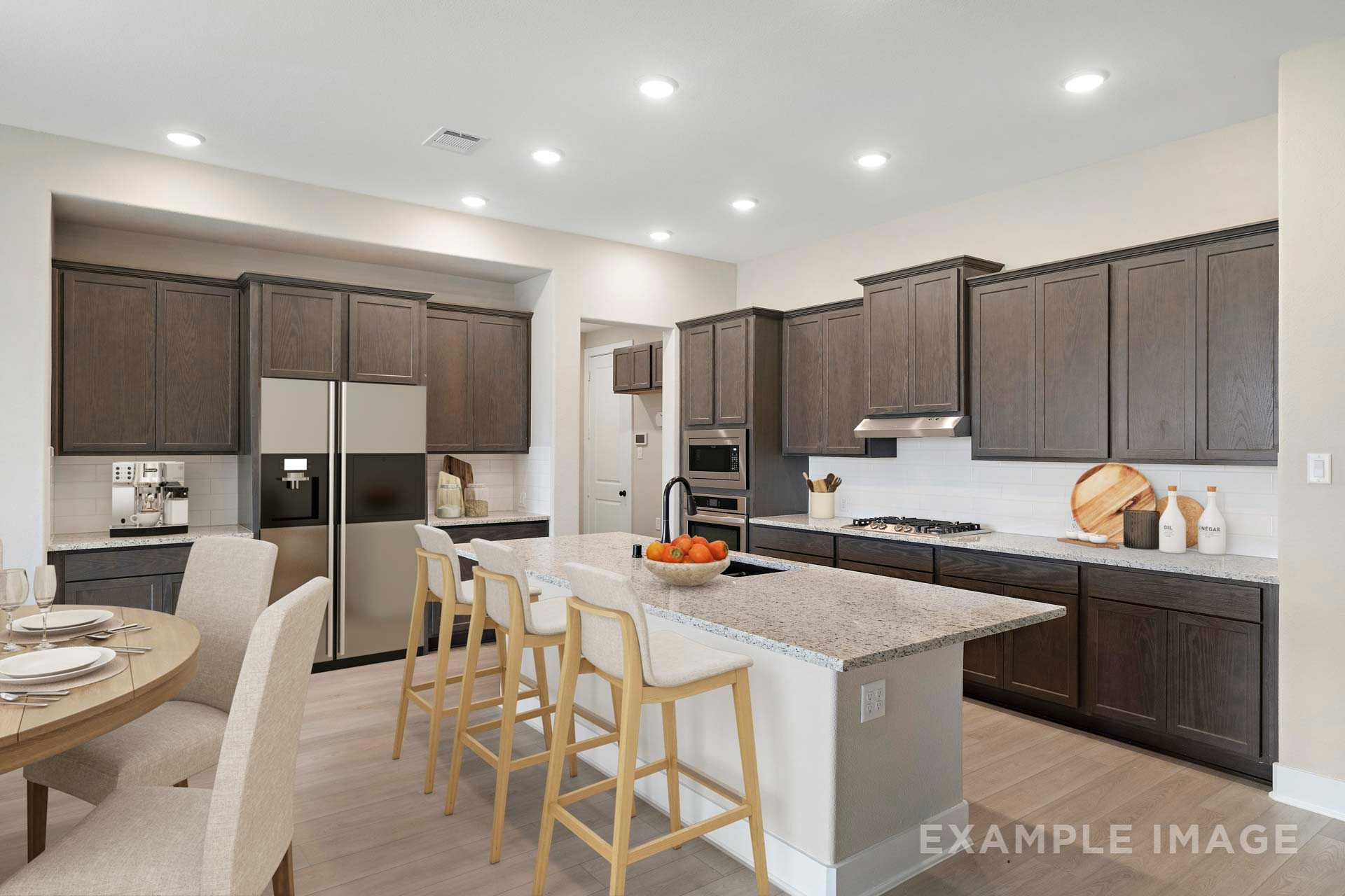 Spacious gourmet kitchen in The Elizabeth A with dark wood cabinets, white quartz island, stainless appliances, and breakfast bar