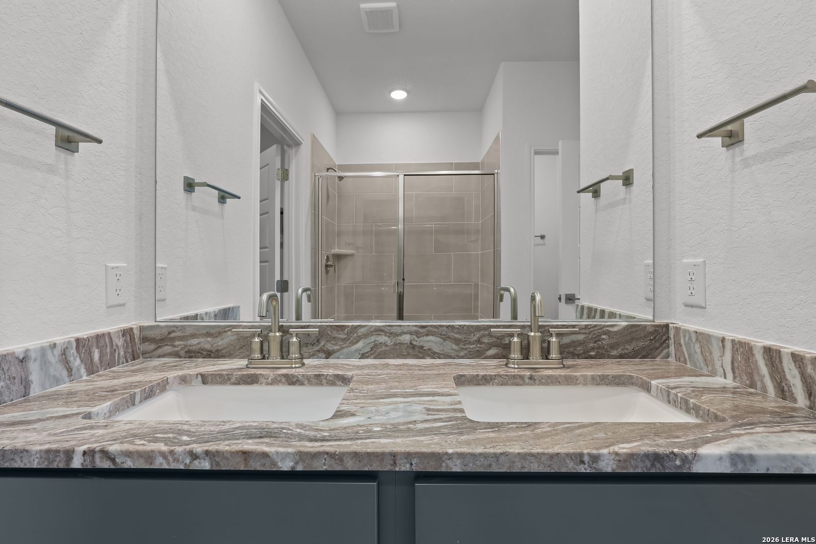 Dual vanity bathroom with marble-style countertops in The Brazos B floor plan by Davidson Homes in Agave, San Antonio.