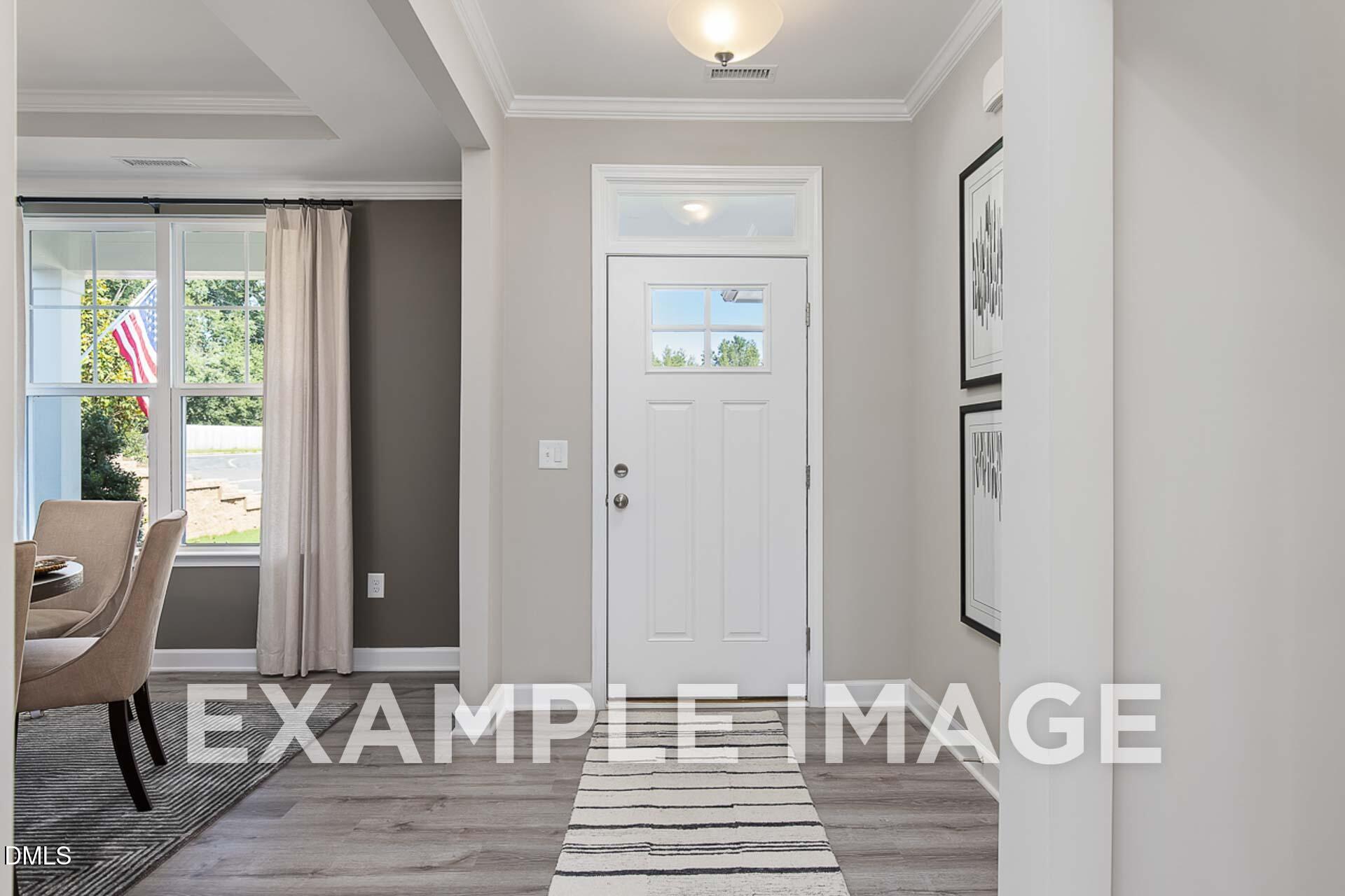 Welcoming entry foyer with white door, gray walls, draped windows, and dining area in Davidson Homes The Ash B, Lillington, NC