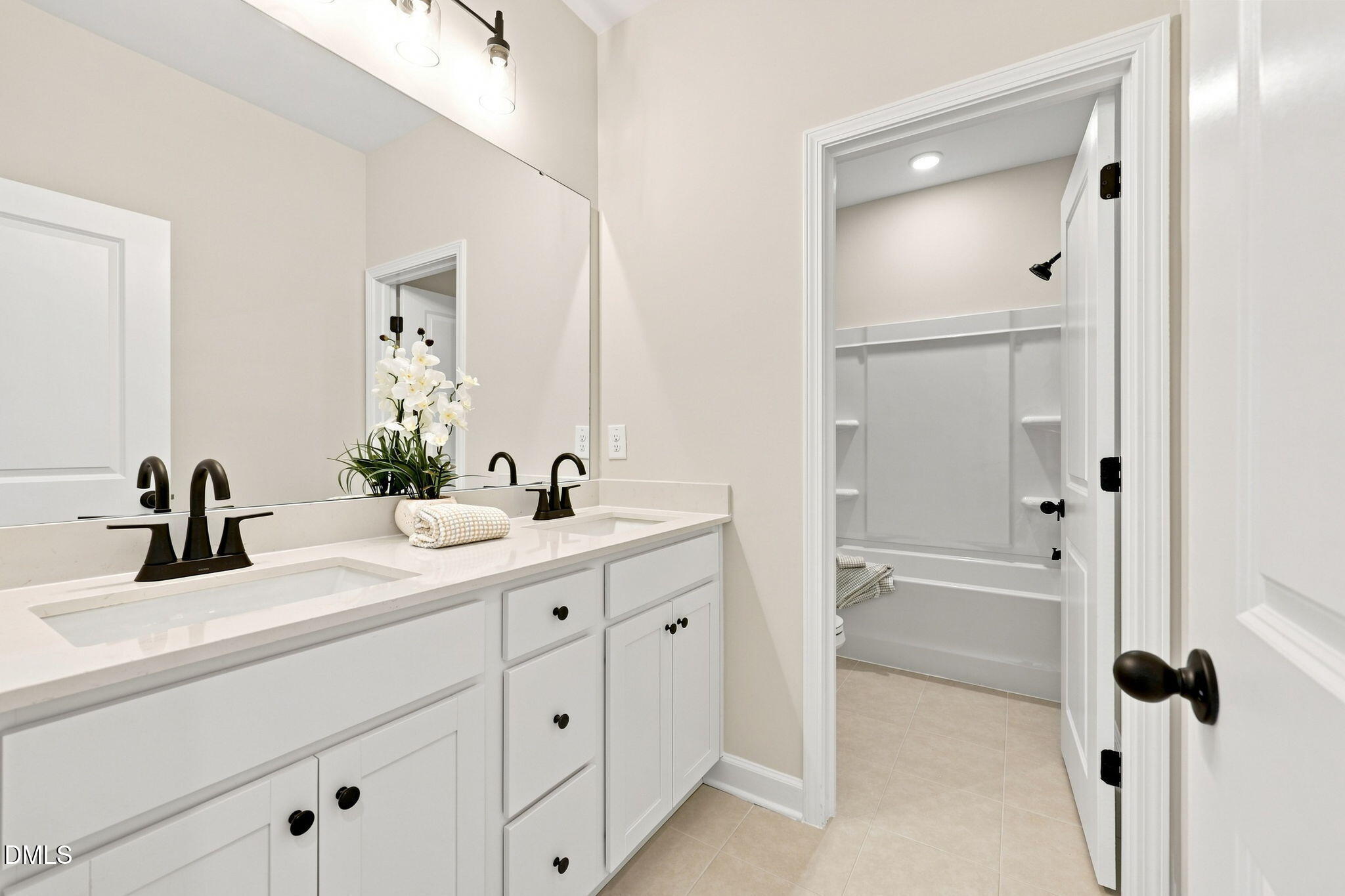 Modern bathroom with dual vanity, quartz countertops, and tub-shower combo in The Harris C at Forestville Yard, Knightdale.