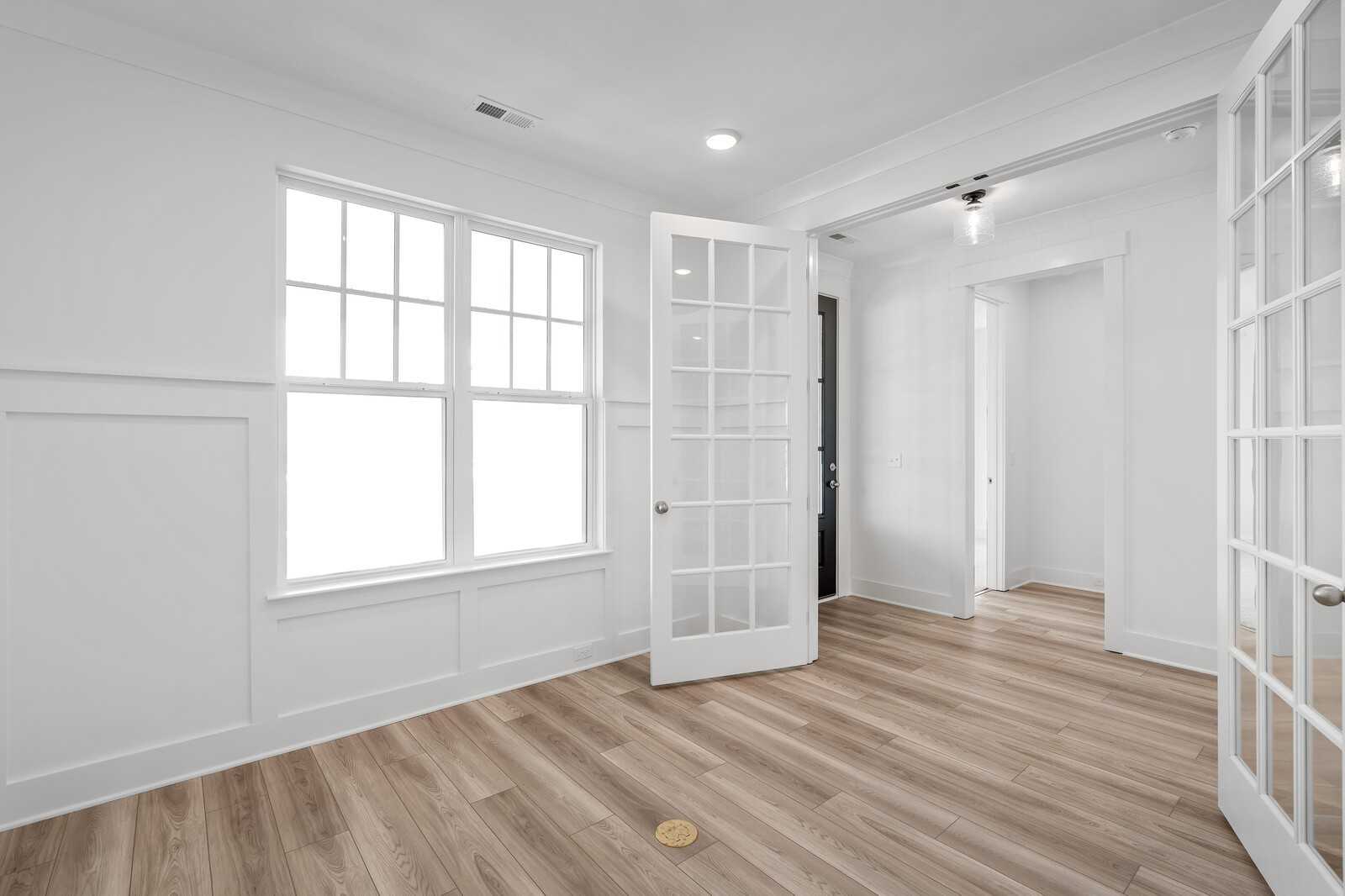 Bright entryway with open French doors, large windows, and hardwood floors in Davidson Homes The Hathaway, Murfreesboro, TN