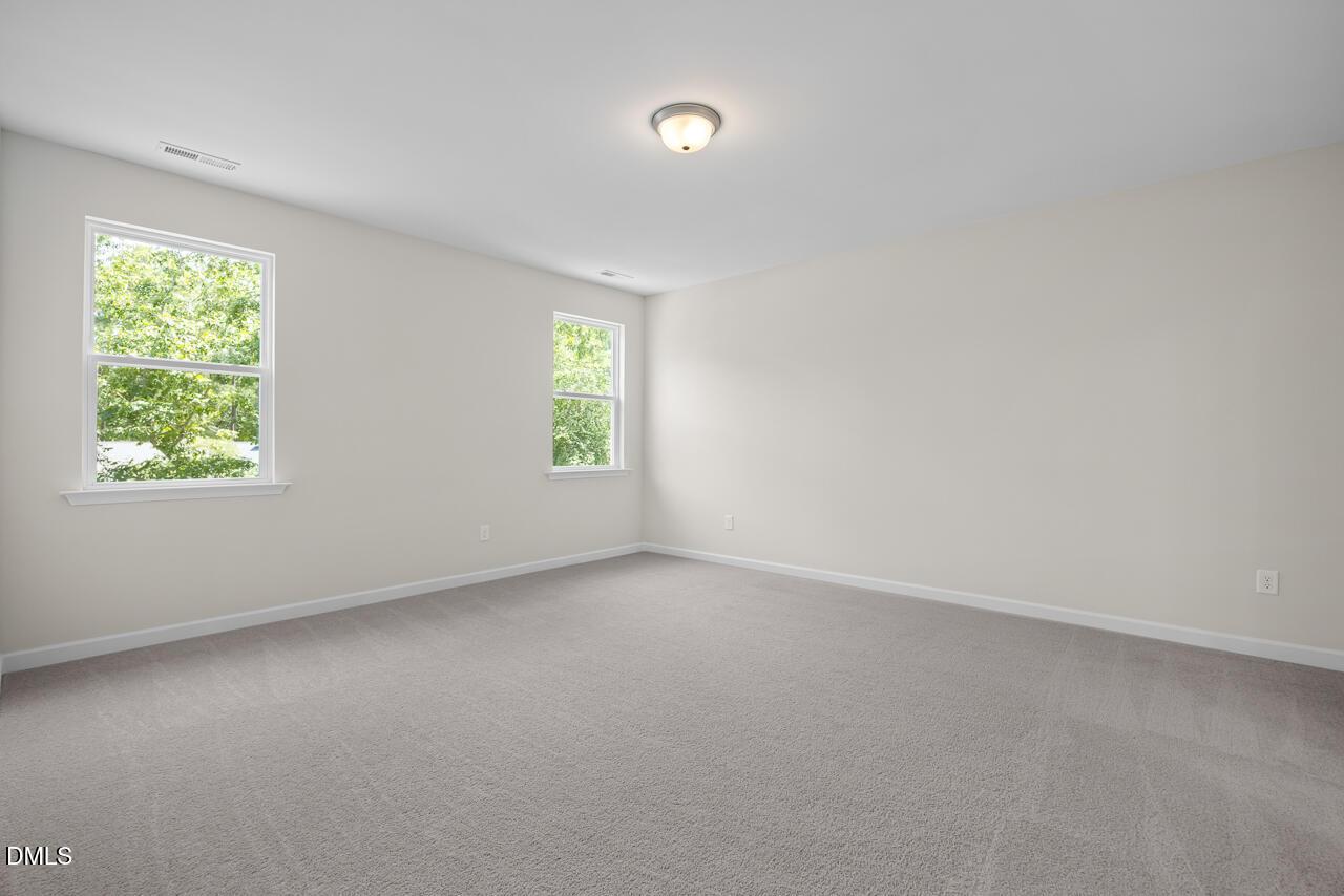 Bright, spacious bedroom with neutral carpet and windows in The Hickory II B floor plan at Montrose, Aberdeen, NC.