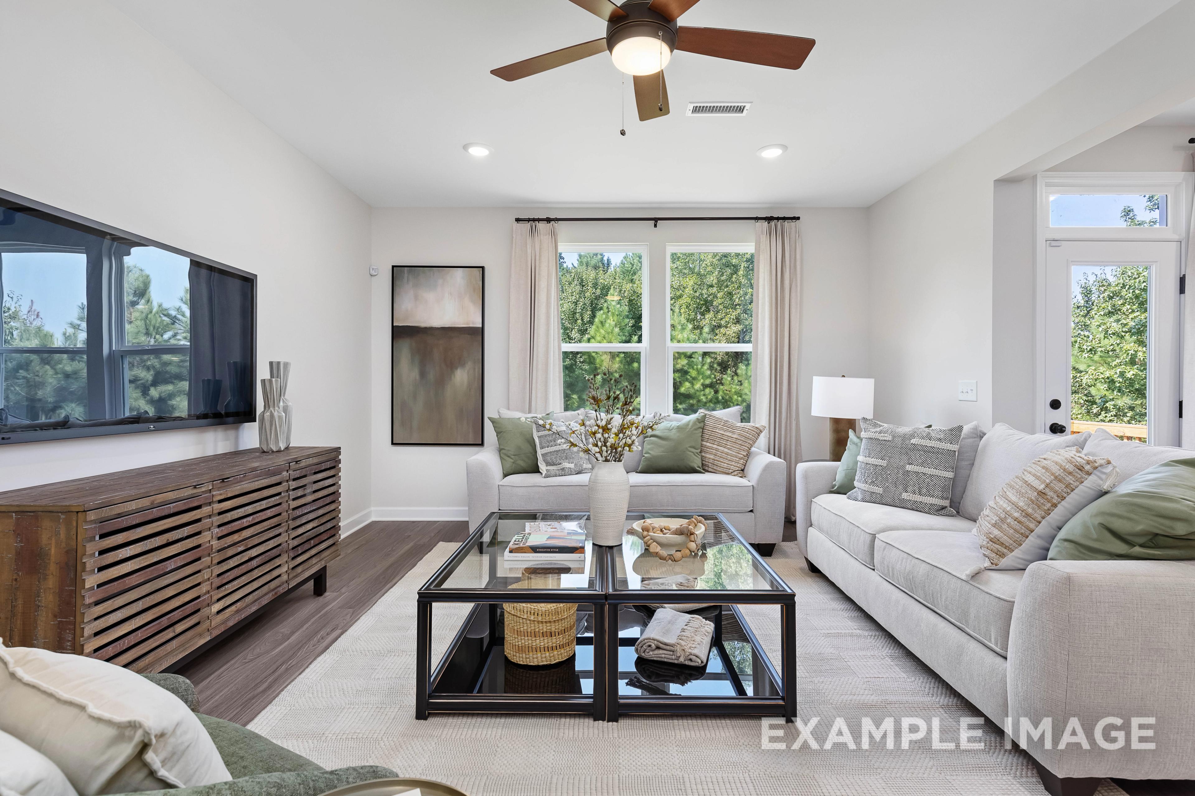 Spacious living room in The Willow B home design by Davidson Homes, featuring beige sectional sofa, glass coffee table, and large windows