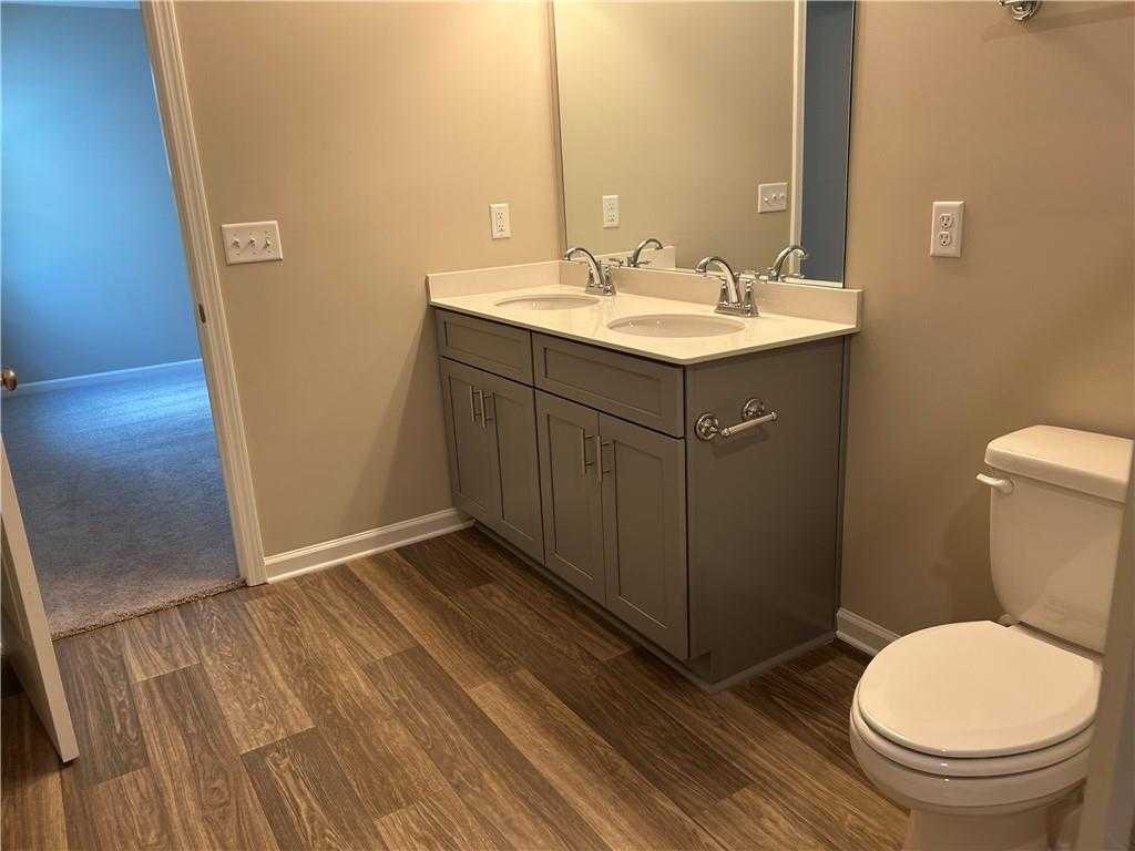 Modern master bathroom featuring double vanity with gray cabinets, dual sinks, and luxury vinyl plank flooring in Davidson Homes The Washington, Phenix City