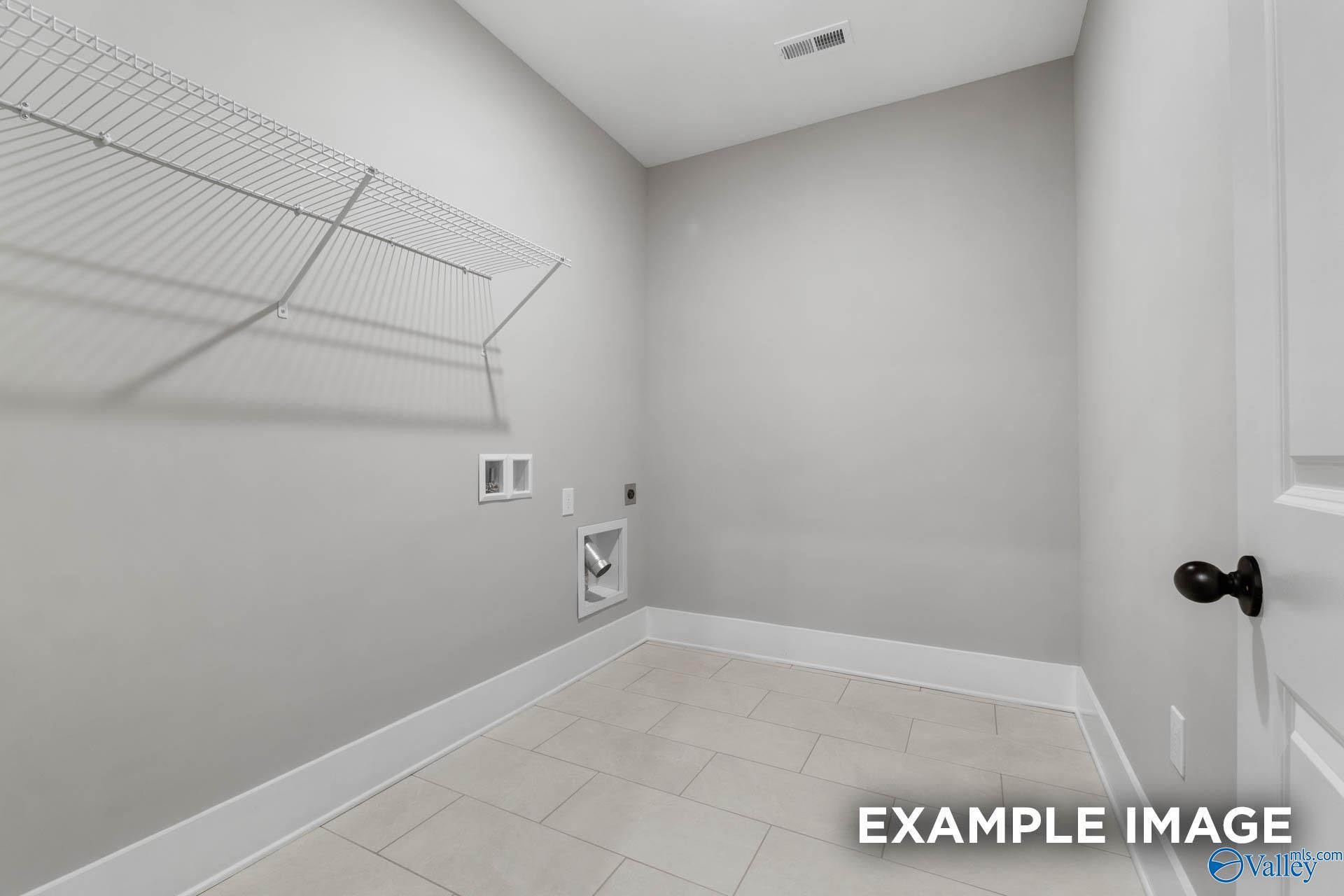 Laundry room with tile flooring and wire shelving in The Finleigh floor plan at Briercreek, Meridianville, Alabama.