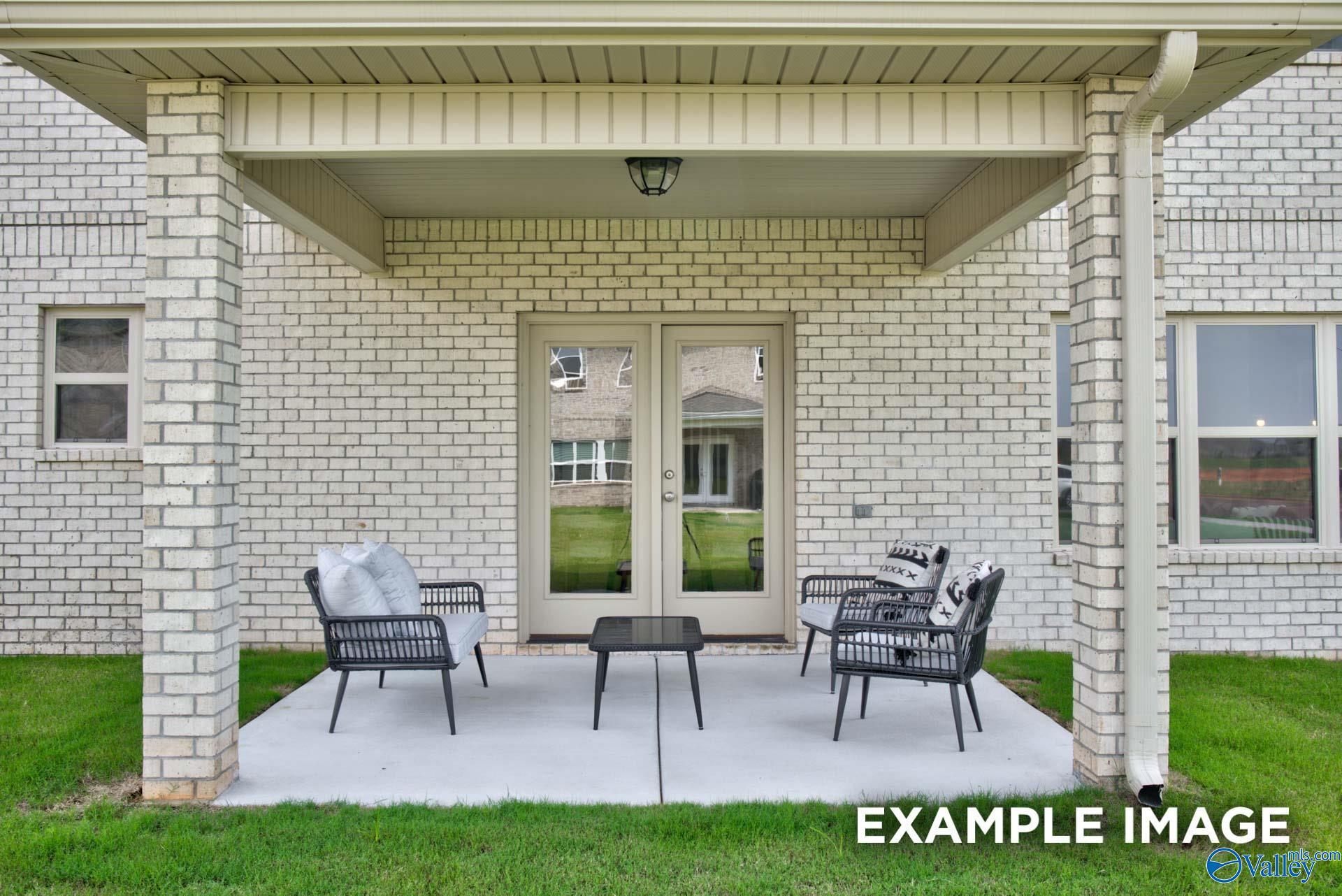 Covered back patio with outdoor seating at The Chelsea A floor plan in Walker's Hill, Meridianville, Alabama.