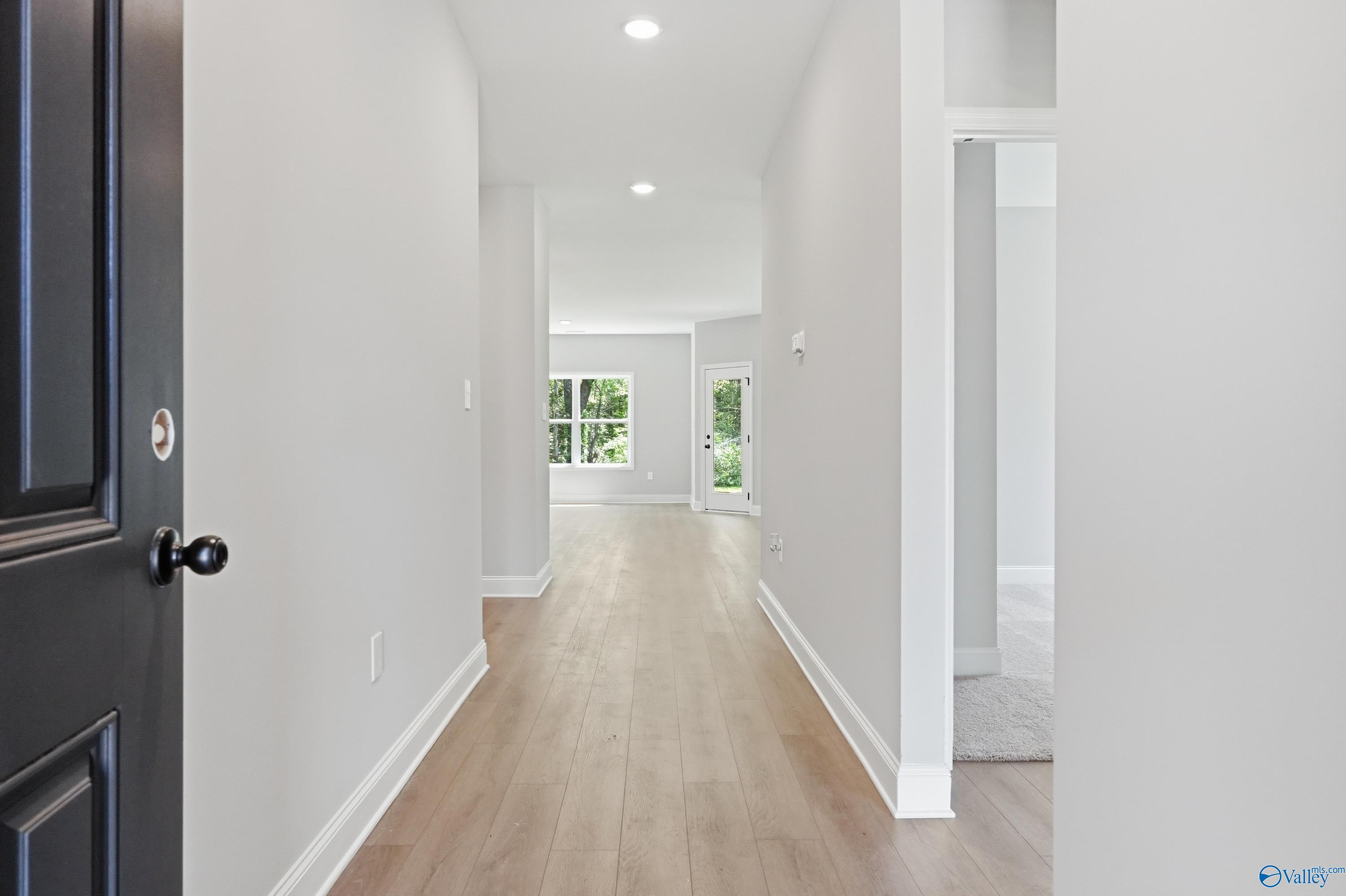 Welcoming entry hallway with light oak floors, gray walls, and natural light in The Franklin 3-bedroom home, Jaguar Hills, Huntsville AL