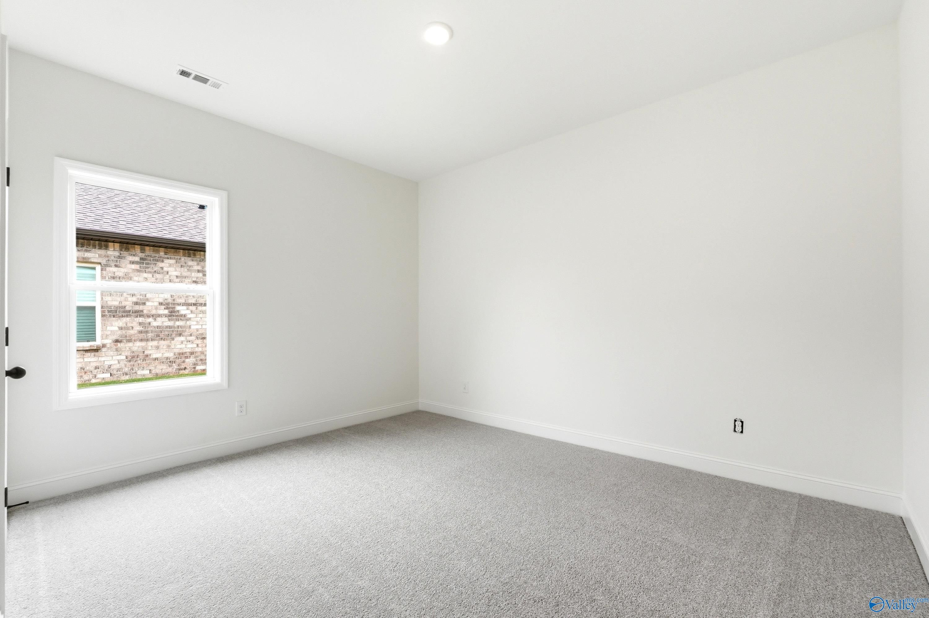 Bright, carpeted bedroom in The Daphne C floor plan at Ivy Hills, Toney, Alabama.