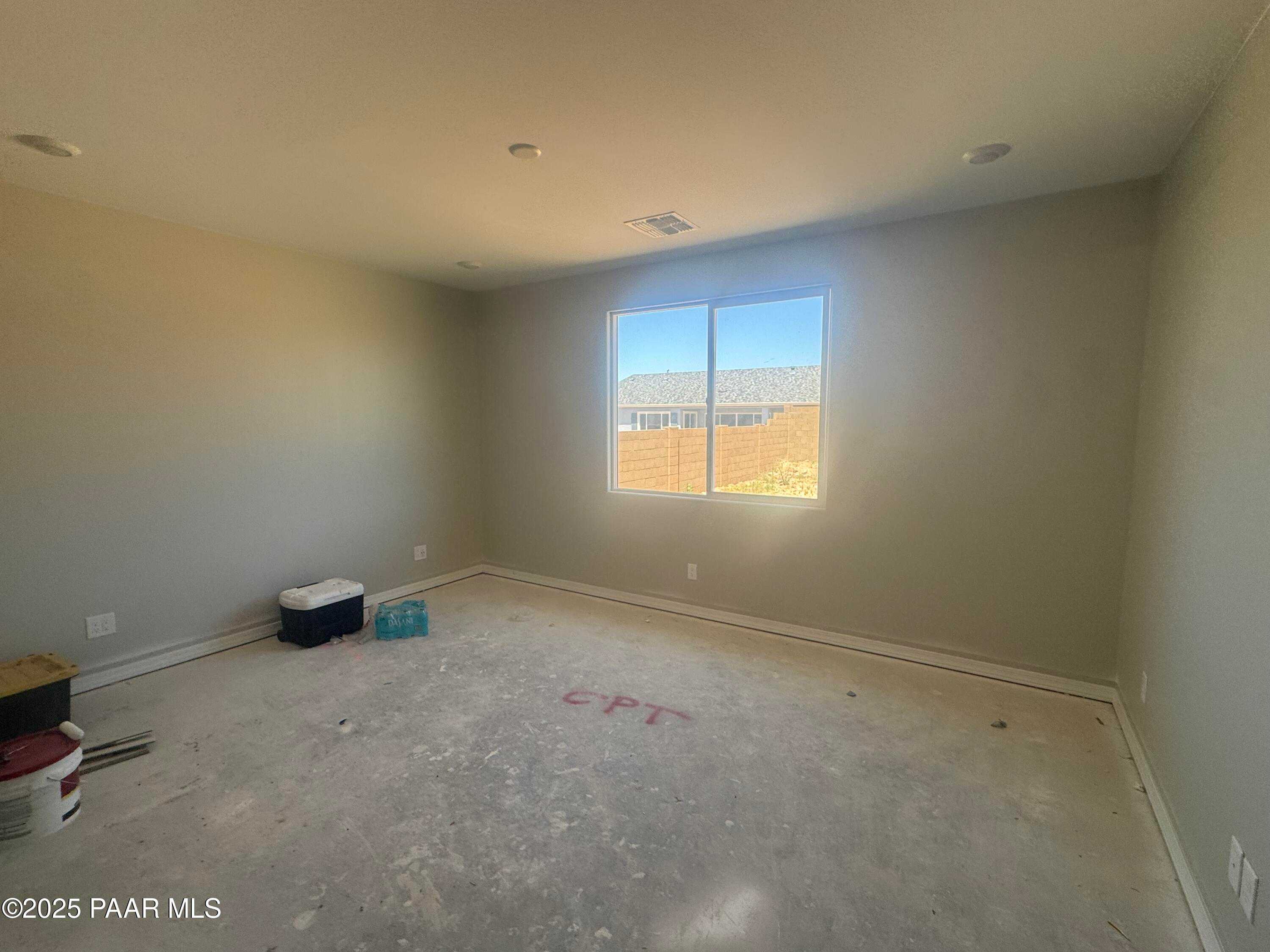 Spacious empty bedroom with large sunny window and neutral walls in Davidson Homes Daybreak E, Prescott Arizona