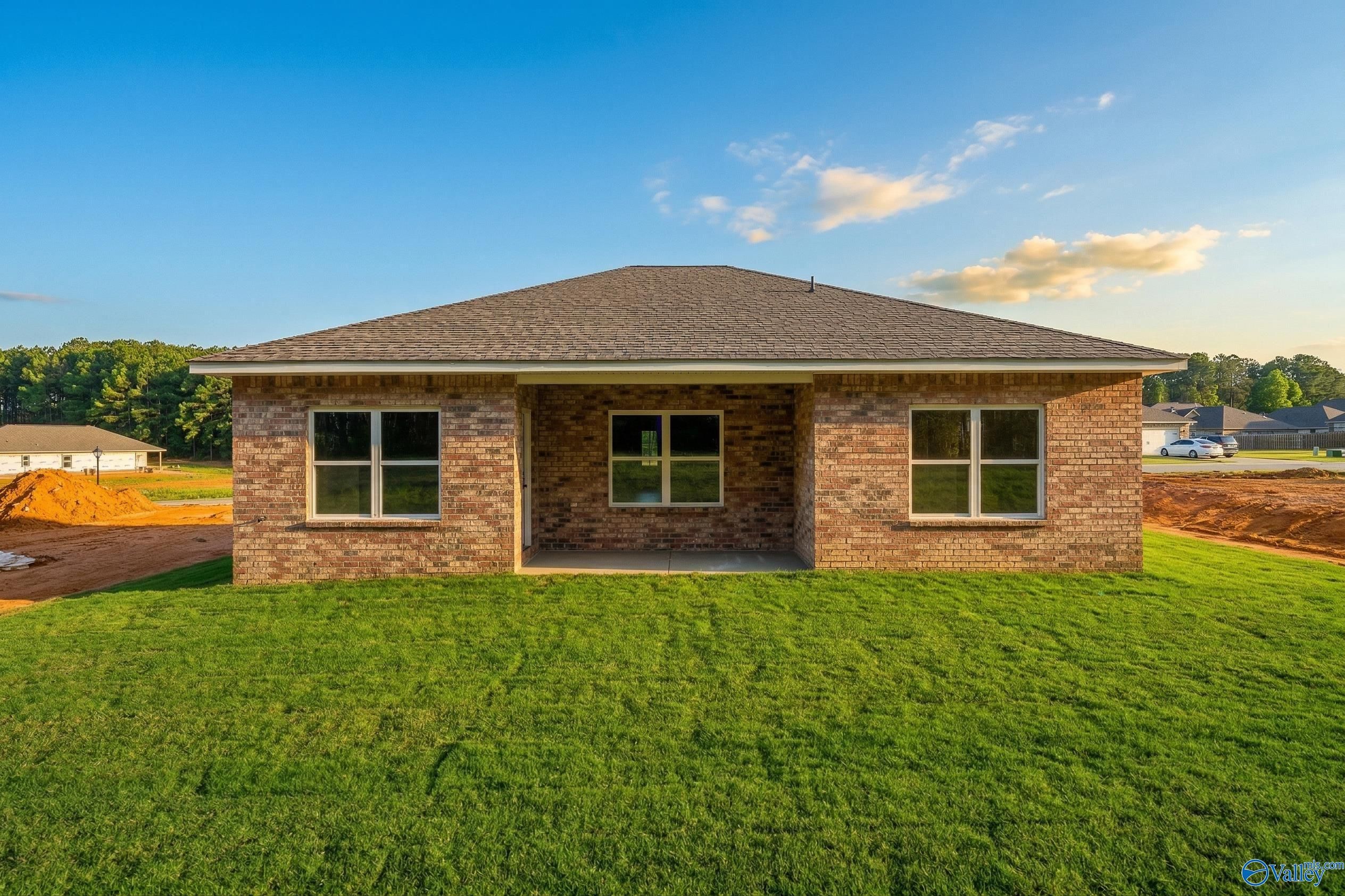 Single-story brick home with covered entry porch, large windows, and manicured lawn in The Highlands, Arab, Alabama