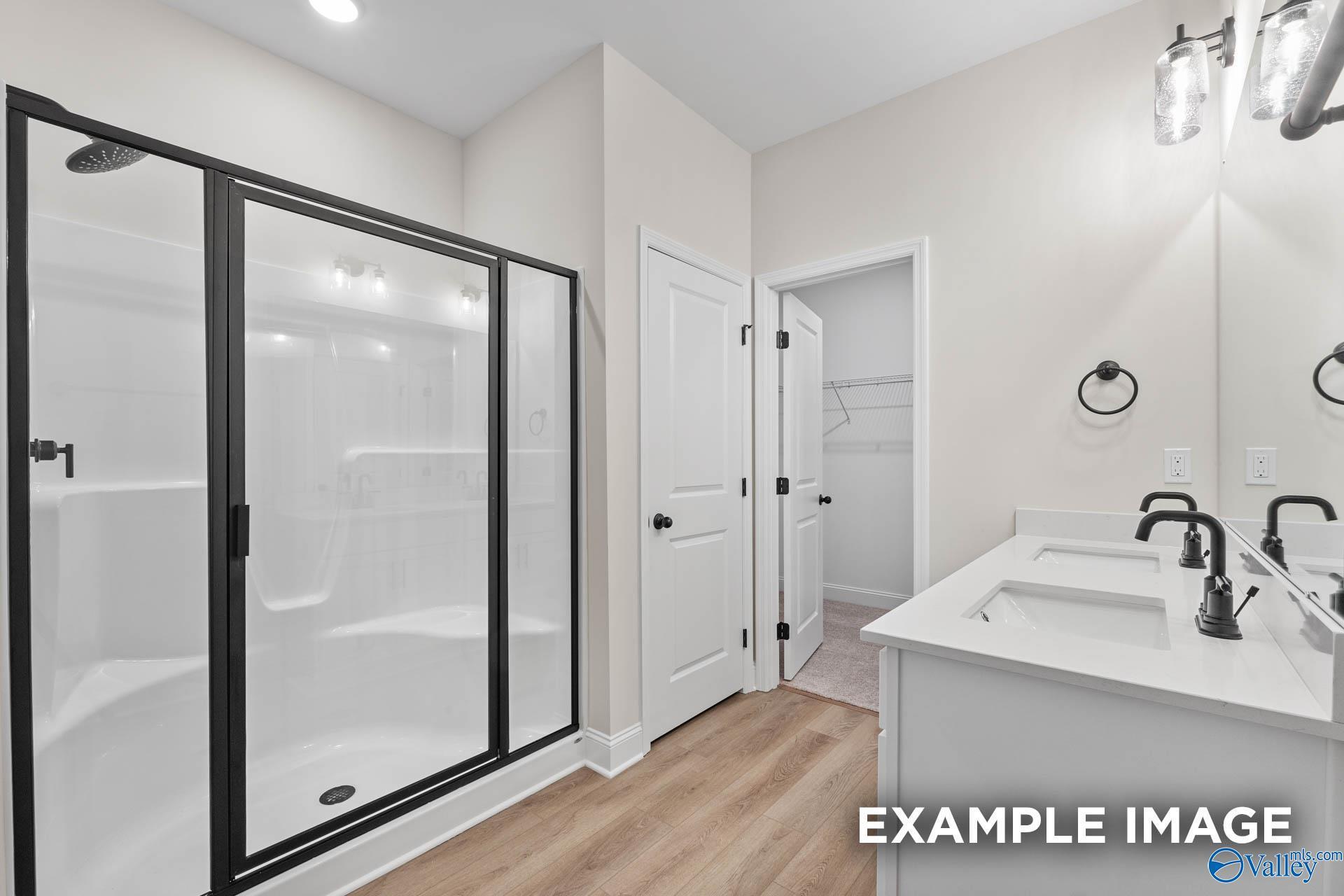 Modern master bathroom with walk-in shower, double vanity, and closet in The Franklin B floor plan by Davidson Homes.