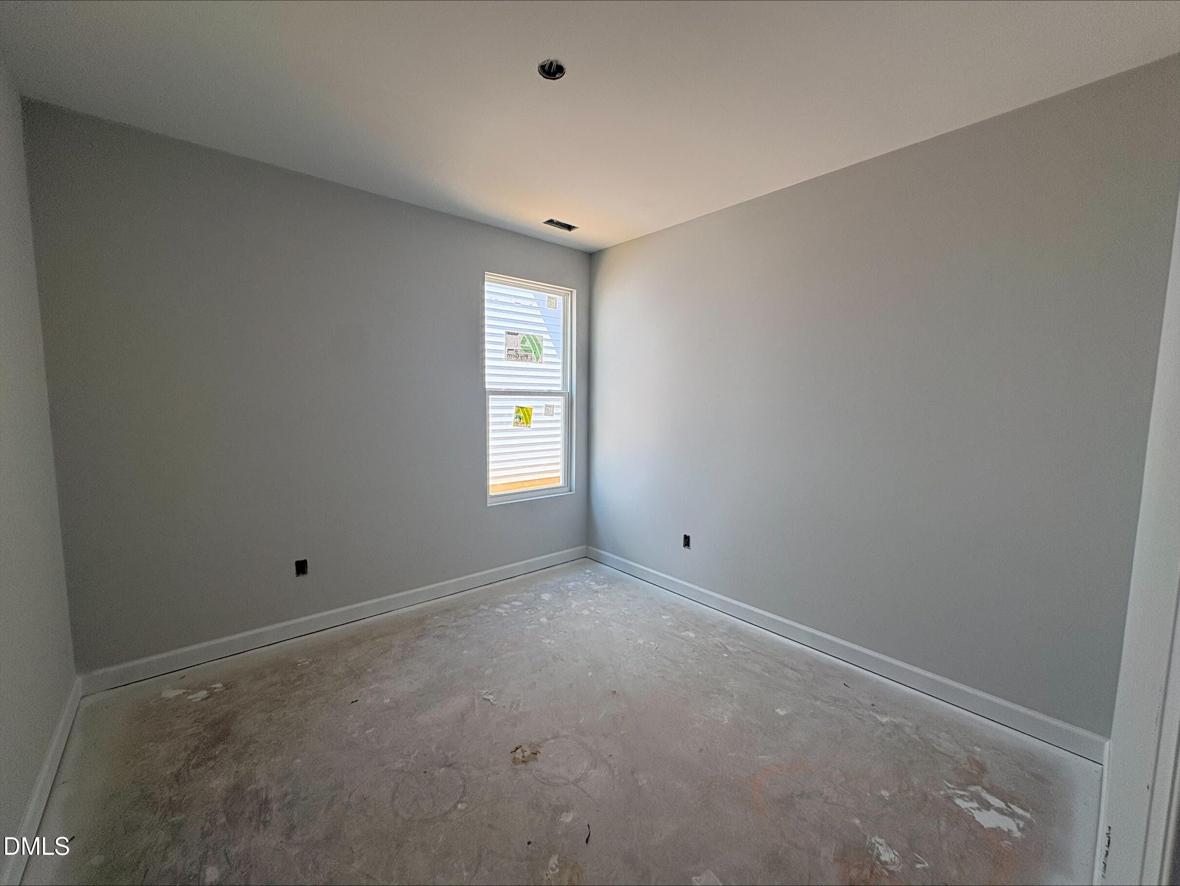 Unfinished bedroom with light grey walls and large window in The Daphne D floor plan, Woodland Crossing, Zebulon, NC.
