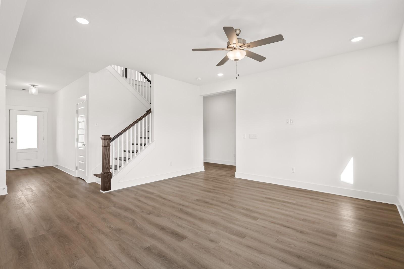 Bright two-story foyer with wooden staircase, hardwood floors, and ceiling fan in The Willow D 4-bedroom home, Mt. Juliet, Tennessee