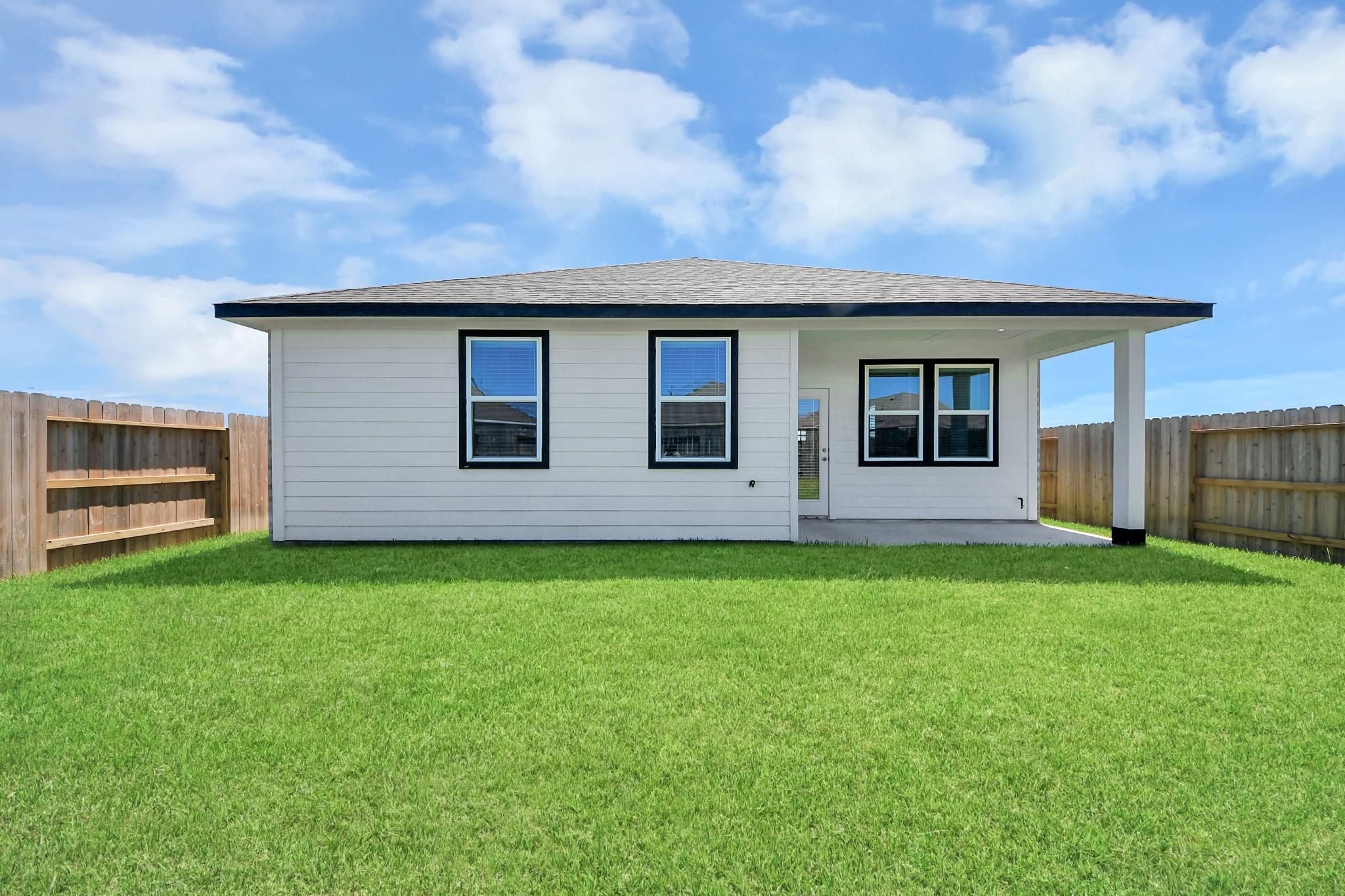 White single-story Davidson Homes Costa A with covered patio, fenced backyard in Emberly, Beasley, Texas