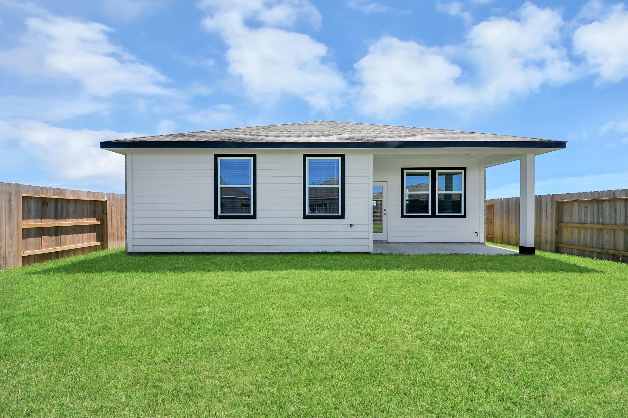 White single-story Davidson Homes Costa A with covered patio, fenced backyard in Emberly, Beasley, Texas