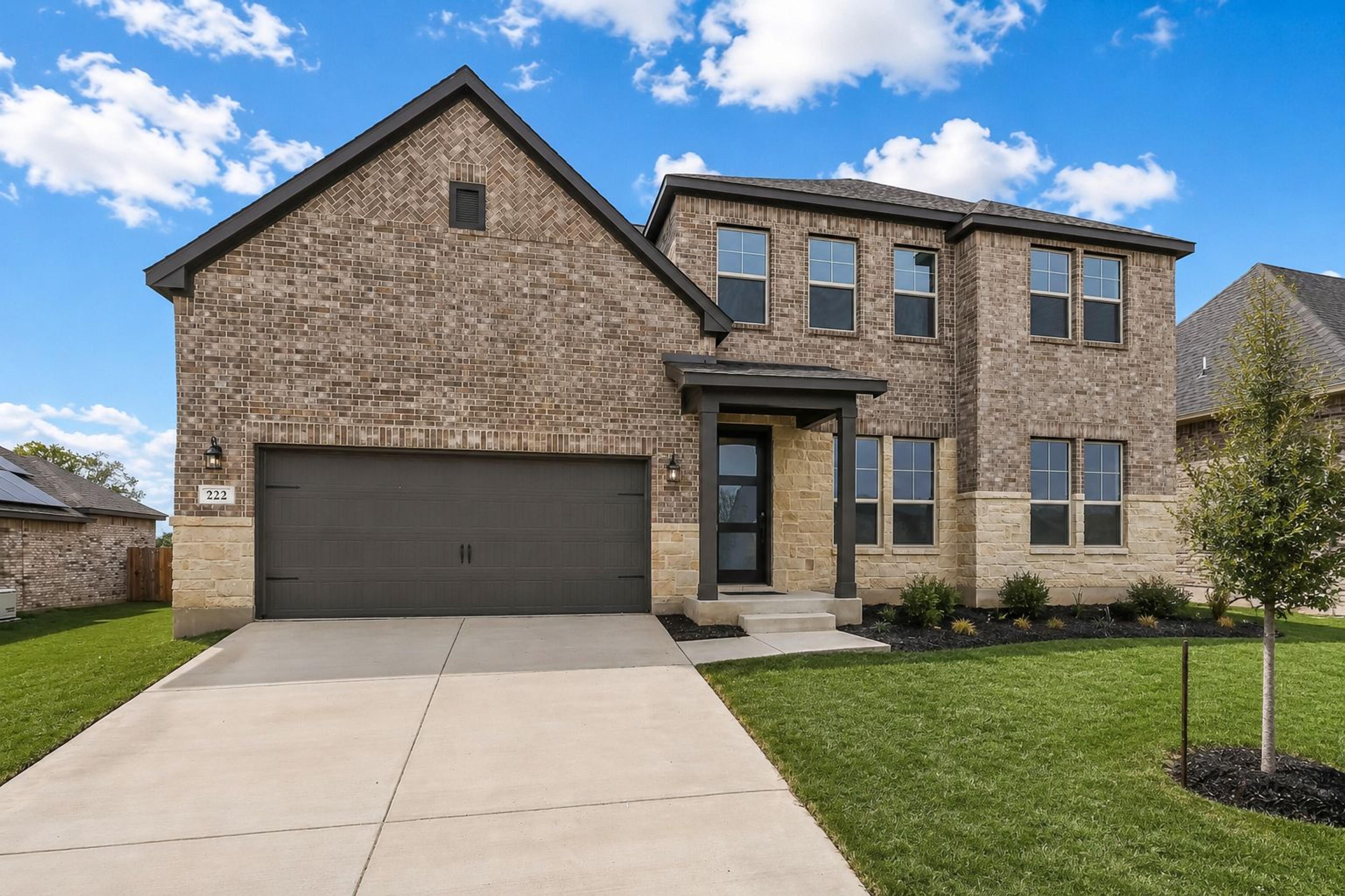 Spacious open-concept living room at Potranco Oaks in Castroville TX with hardwood floors modern sofa sliding doors to scenic patio and sleek kitchen
