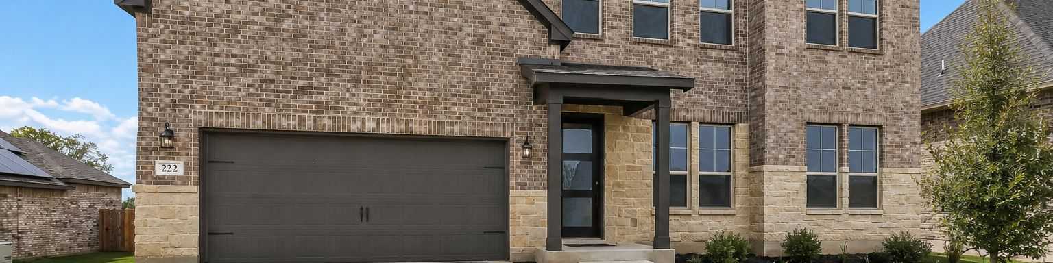 Spacious open-concept living room at Potranco Oaks in Castroville TX with hardwood floors modern sofa sliding doors to scenic patio and sleek kitchen