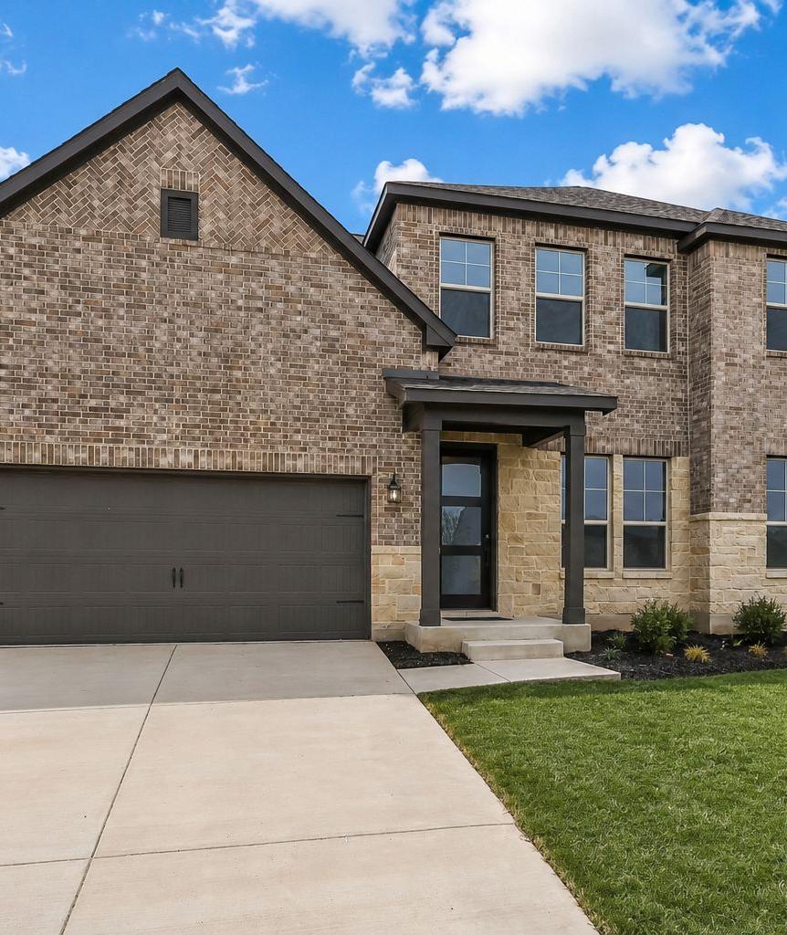 Spacious open-concept living room at Potranco Oaks in Castroville TX with hardwood floors modern sofa sliding doors to scenic patio and sleek kitchen