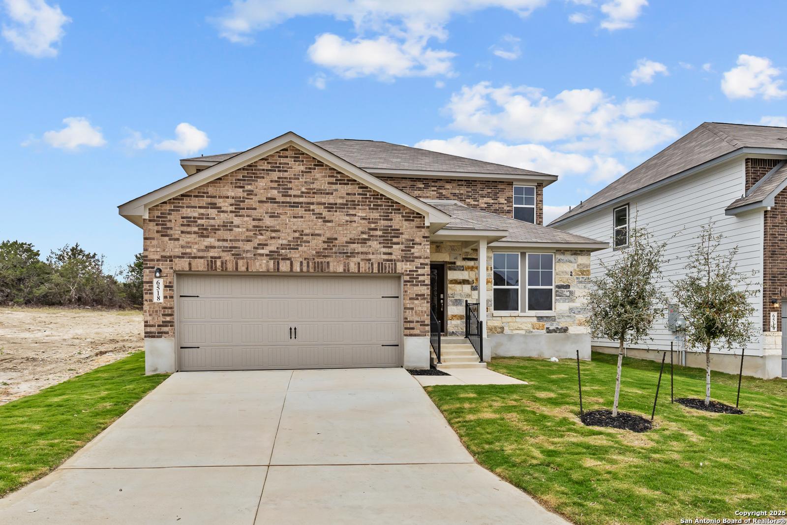 Modern two-story brick home with two-car garage, front porch, and landscaped yard in Royal Crest, San Antonio, Texas by Davidson Homes The Douglas F
