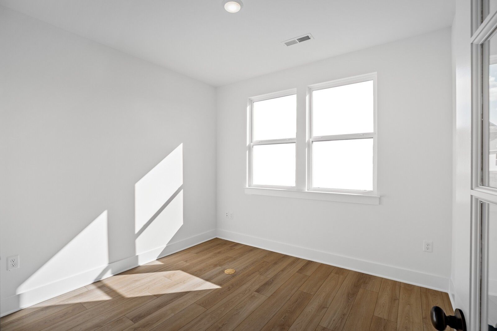 Bright secondary bedroom with hardwood floors, large windows, and natural light in Davidson Homes The Willow C, Gallatin, TN