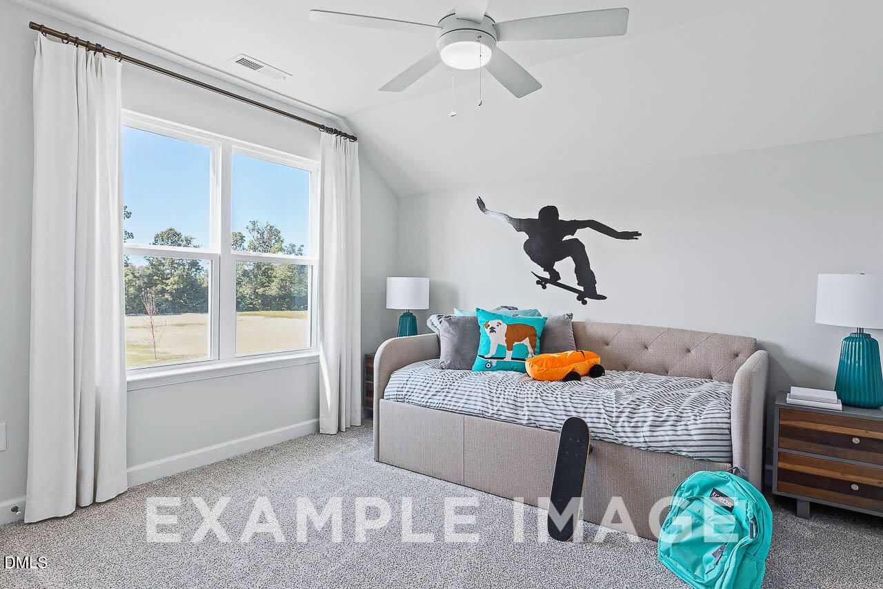 Bright bedroom with daybed, vaulted ceiling, and large windows in Davidson Homes The Ash C plan, Lillington, NC