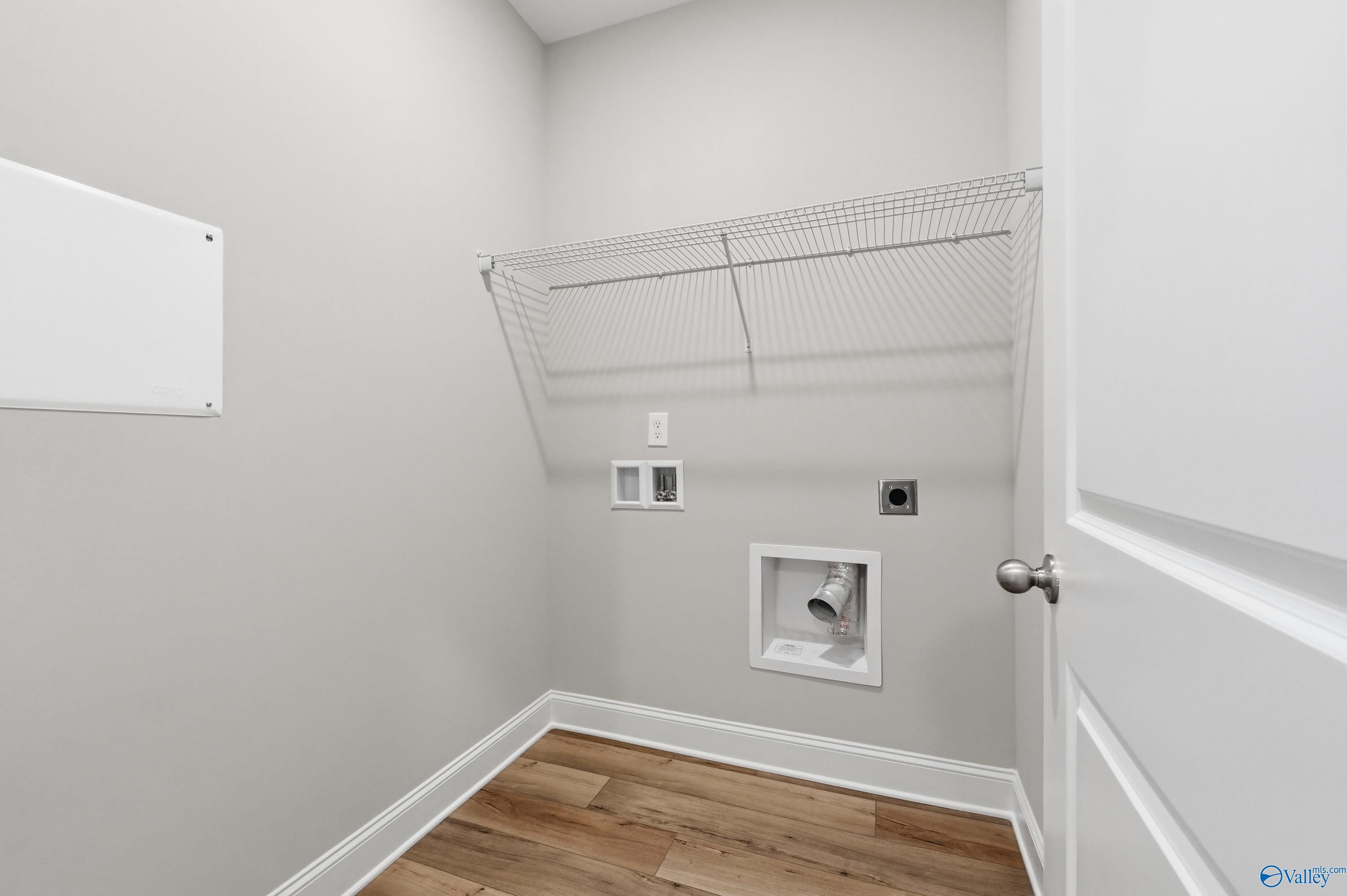 Spacious laundry room with wire shelving, utility sink, and washer/dryer hookups in The Asheville by Davidson Homes, Huntsville, Alabama