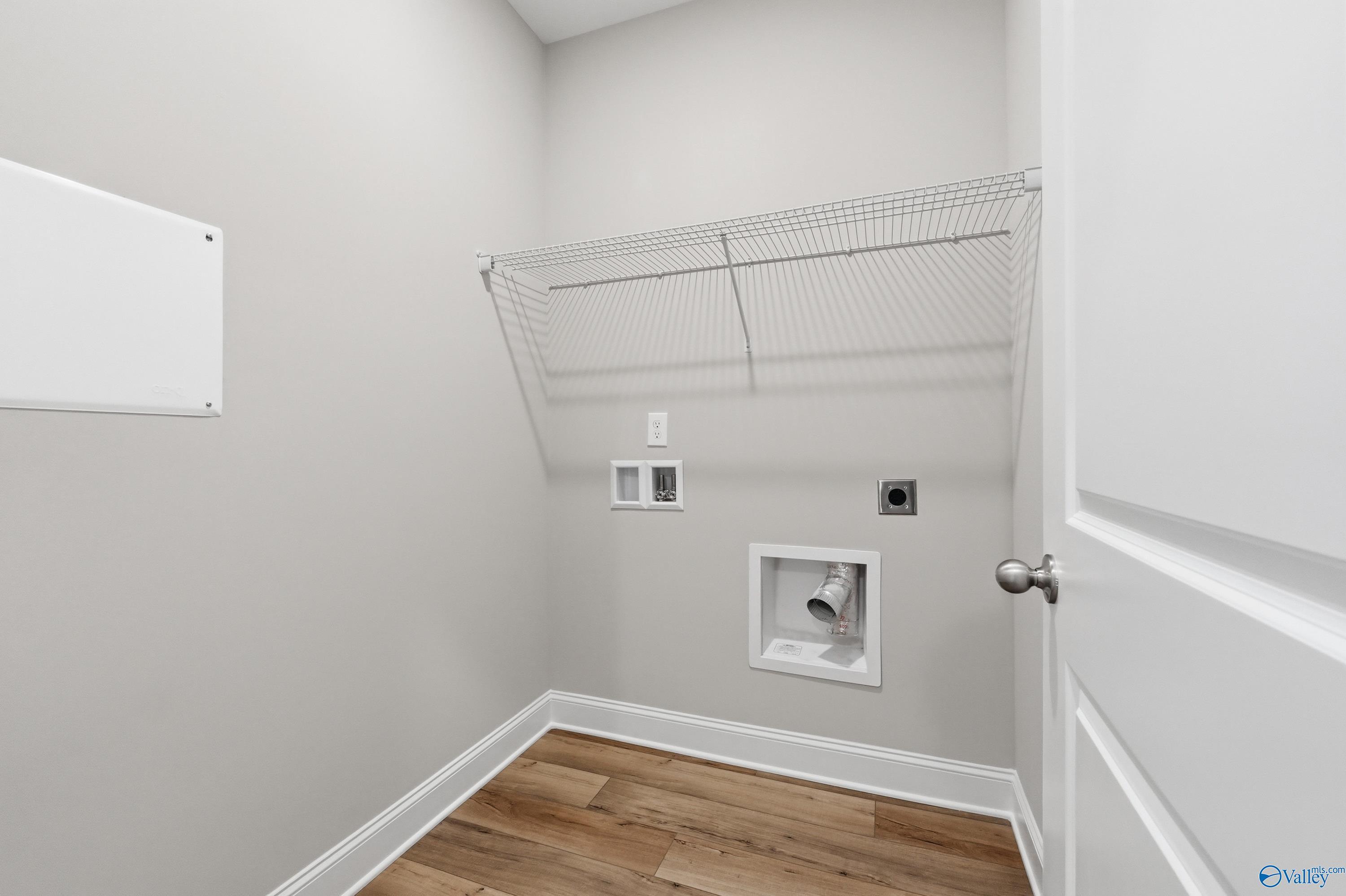 Spacious laundry room with wire shelving, utility sink, and washer/dryer hookups in The Asheville by Davidson Homes, Huntsville, Alabama