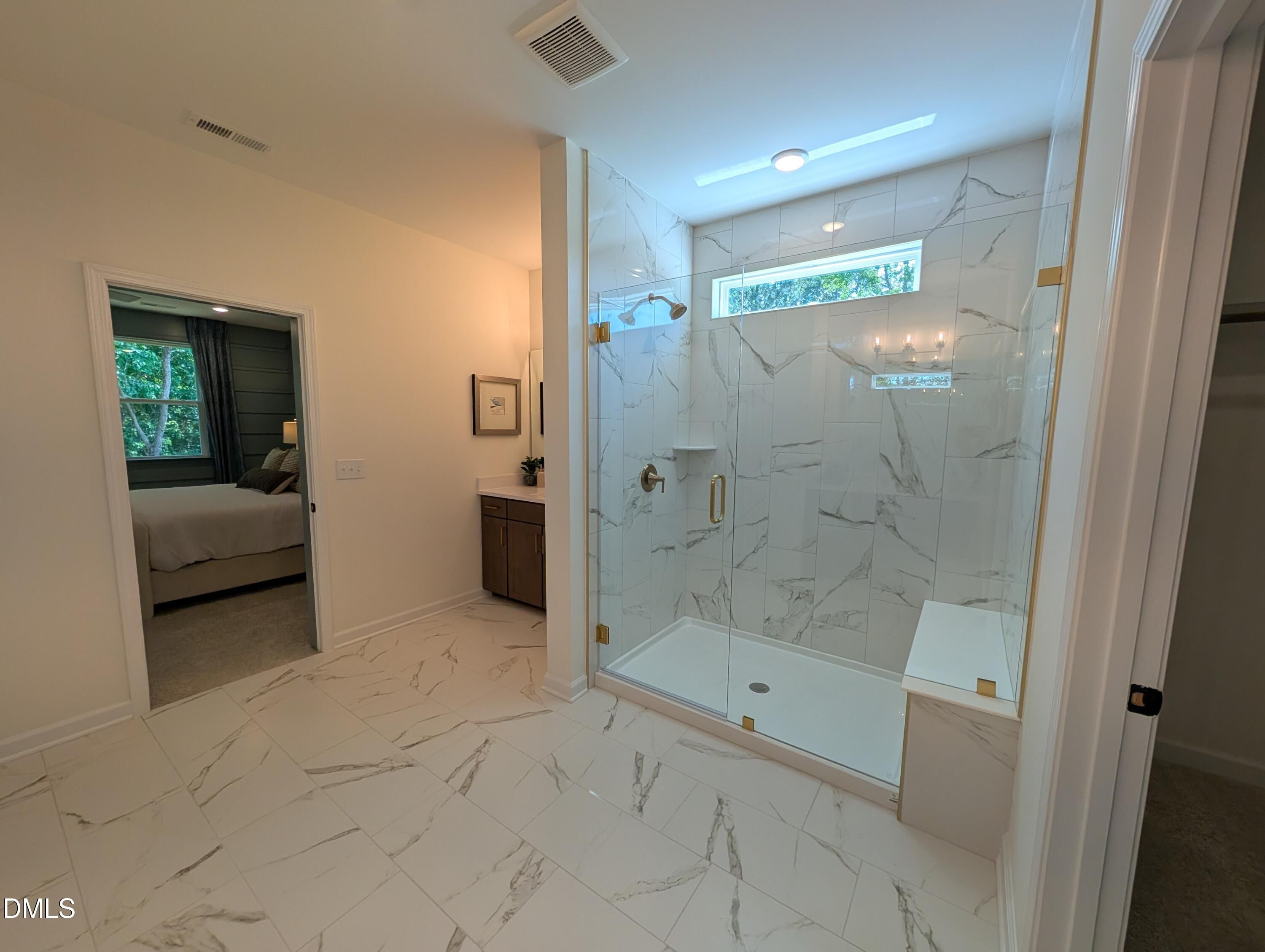 Luxurious walk-in shower with marble tile and glass enclosure in The Aspen B floor plan at Wendell Ridge, North Carolina.