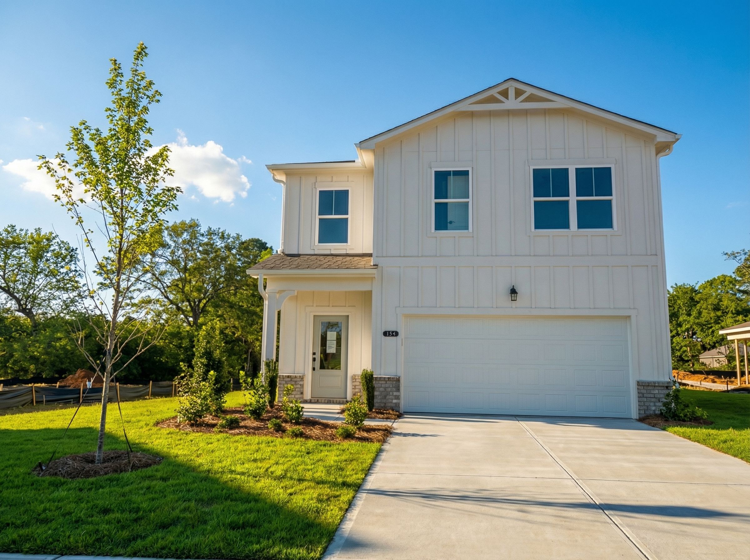 Two-story white Rabun C home by Davidson Homes in Cedar Farms, Winder, Georgia: 2-car garage, front porch, landscaped yard