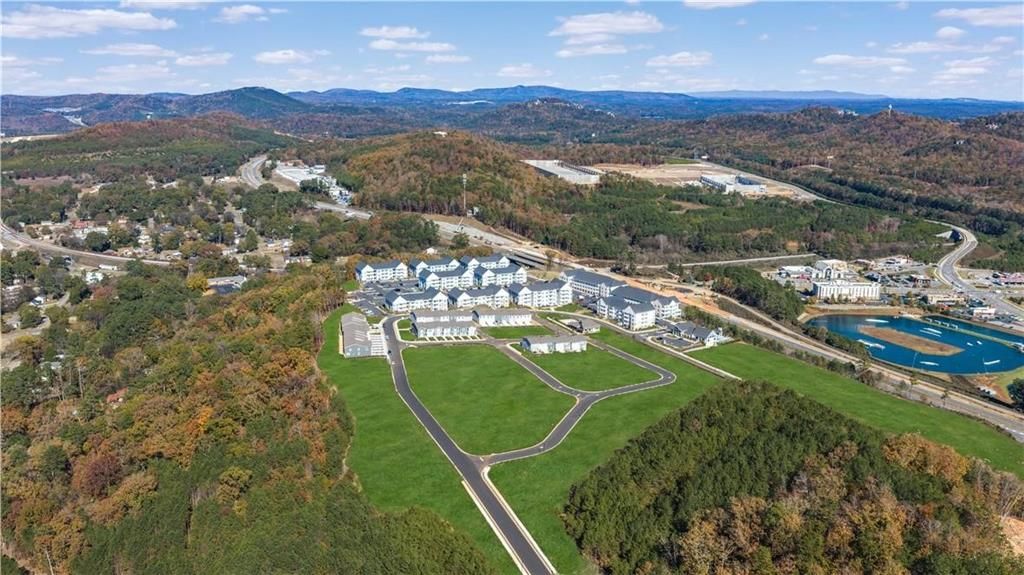 Aerial view of Stegall Village townhomes by Davidson Homes in Emerson, Georgia, with green lawns, community lake, and rolling hills