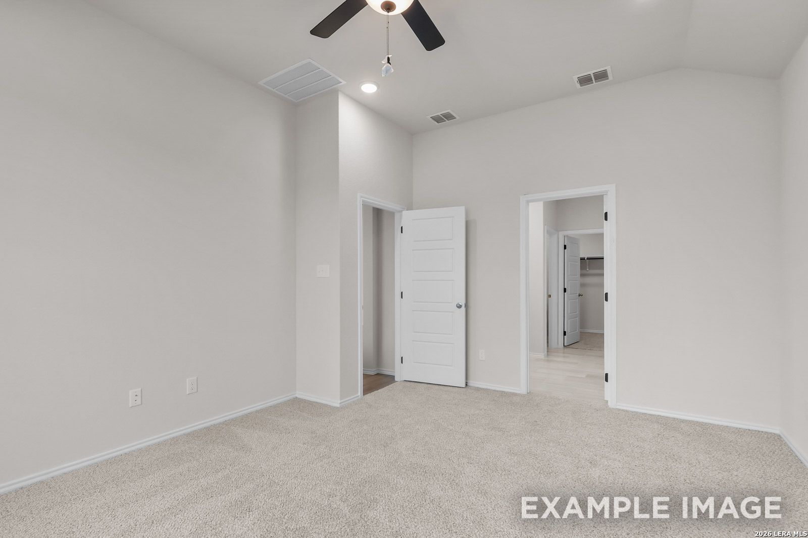 Spacious bedroom with vaulted ceilings, ceiling fan, and walk-in closet in The Sequoia C floor plan, Royal Crest, San Antonio.