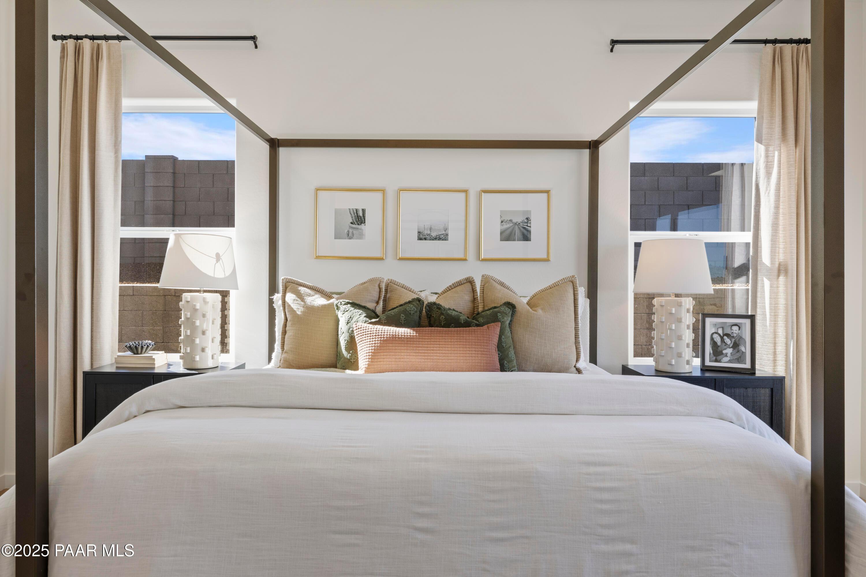 Luxurious master bedroom with king bed, neutral pillows, bedside lamps, and desert-view windows in Davidson Homes The Blaze D, Prescott