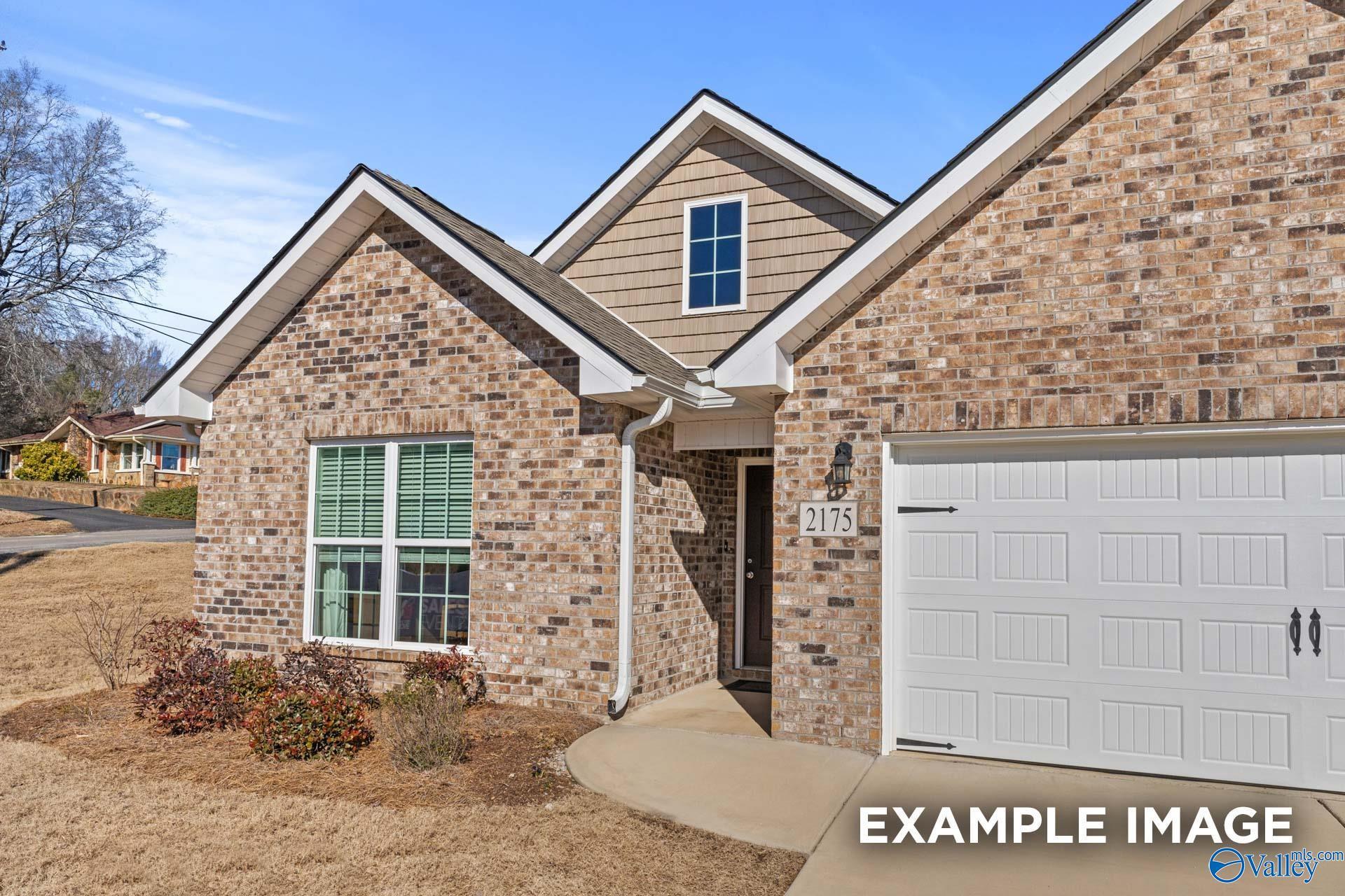 Brick single-story home exterior with 2-car garage, gabled roof, and front entry in Creek Grove, New Market, Alabama
