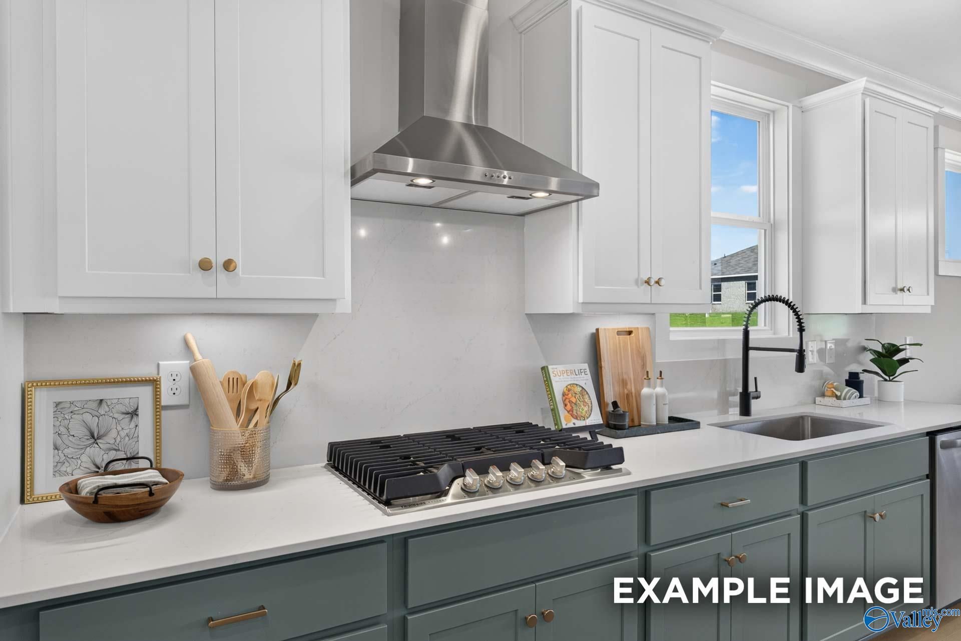 White shaker cabinets, quartz countertops, gas cooktop, and black matte faucet in Davidson Homes The Ashport K kitchen, Hazel Green, Alabama