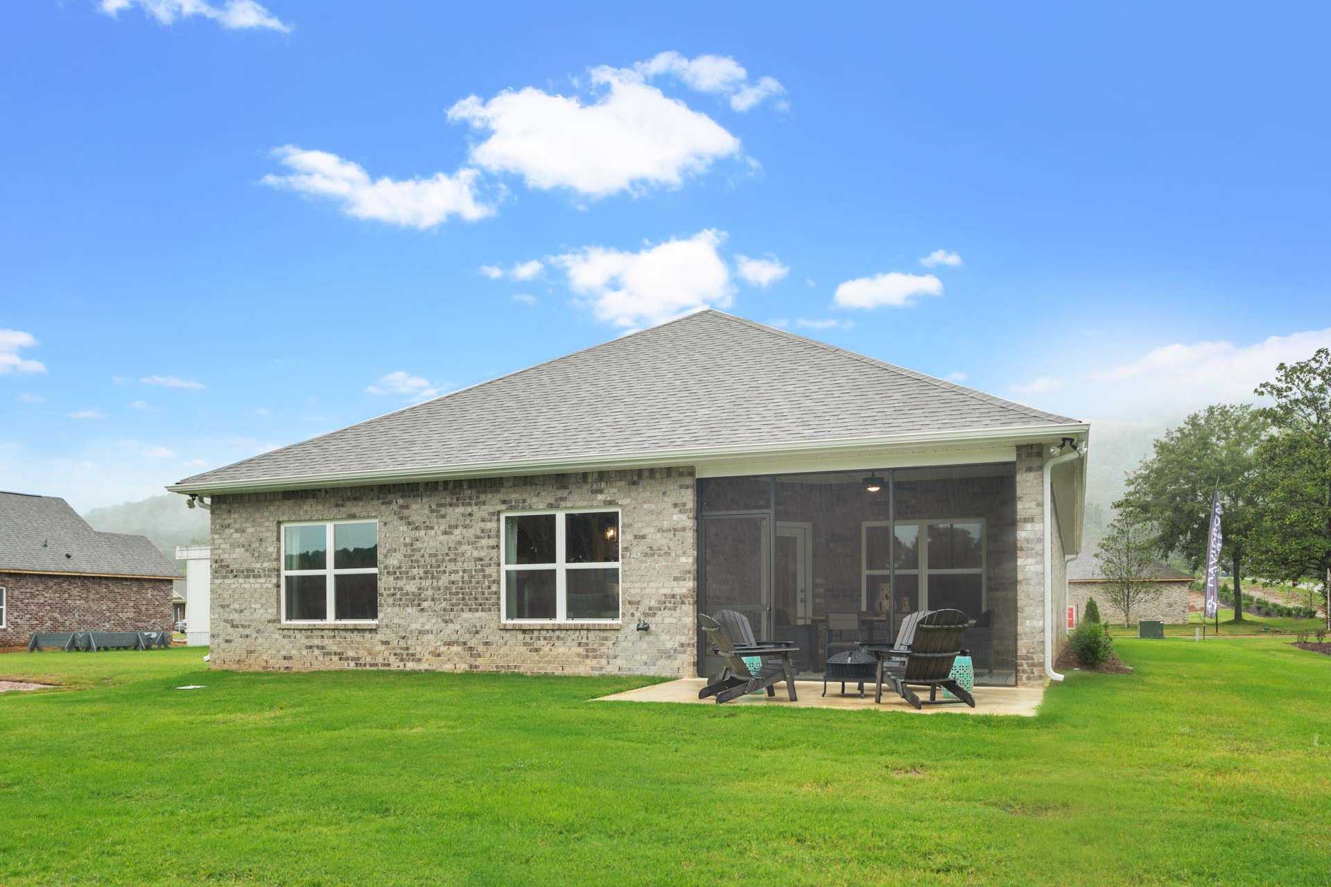 Brick home rear exterior at Monteagle Cove in Owens Cross Roads Alabama with screened porch and Adirondack chairs