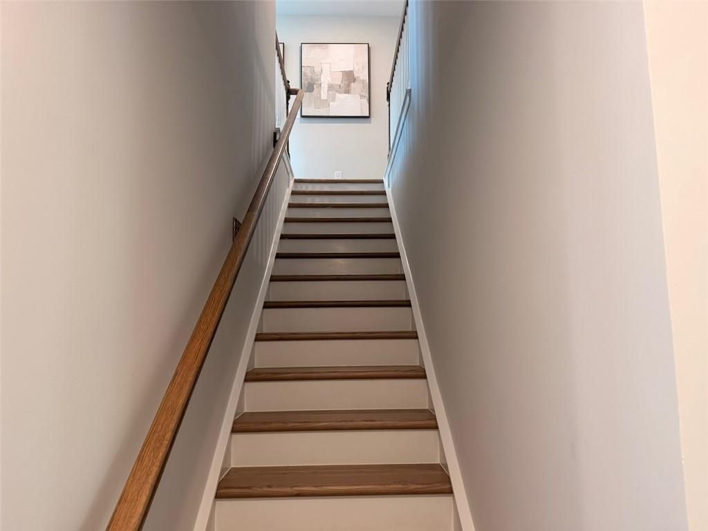 Hardwood staircase with wooden handrail leading to second floor in Davidson Homes Pinecrest J, Greene Farm, Cartersville GA