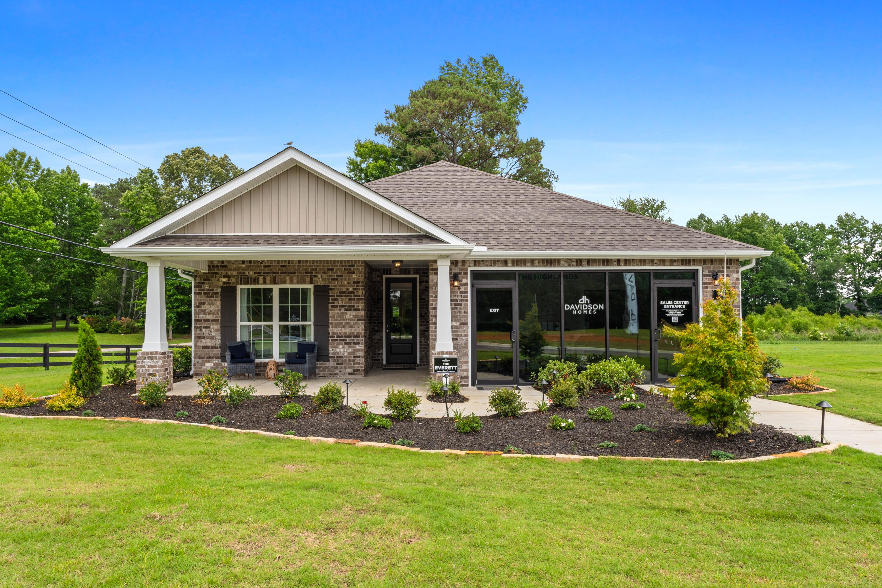 Craftsman-style home exterior at The Highlands in Arab Alabama by Davidson Homes with covered porch, brick accents, and landscaped yard