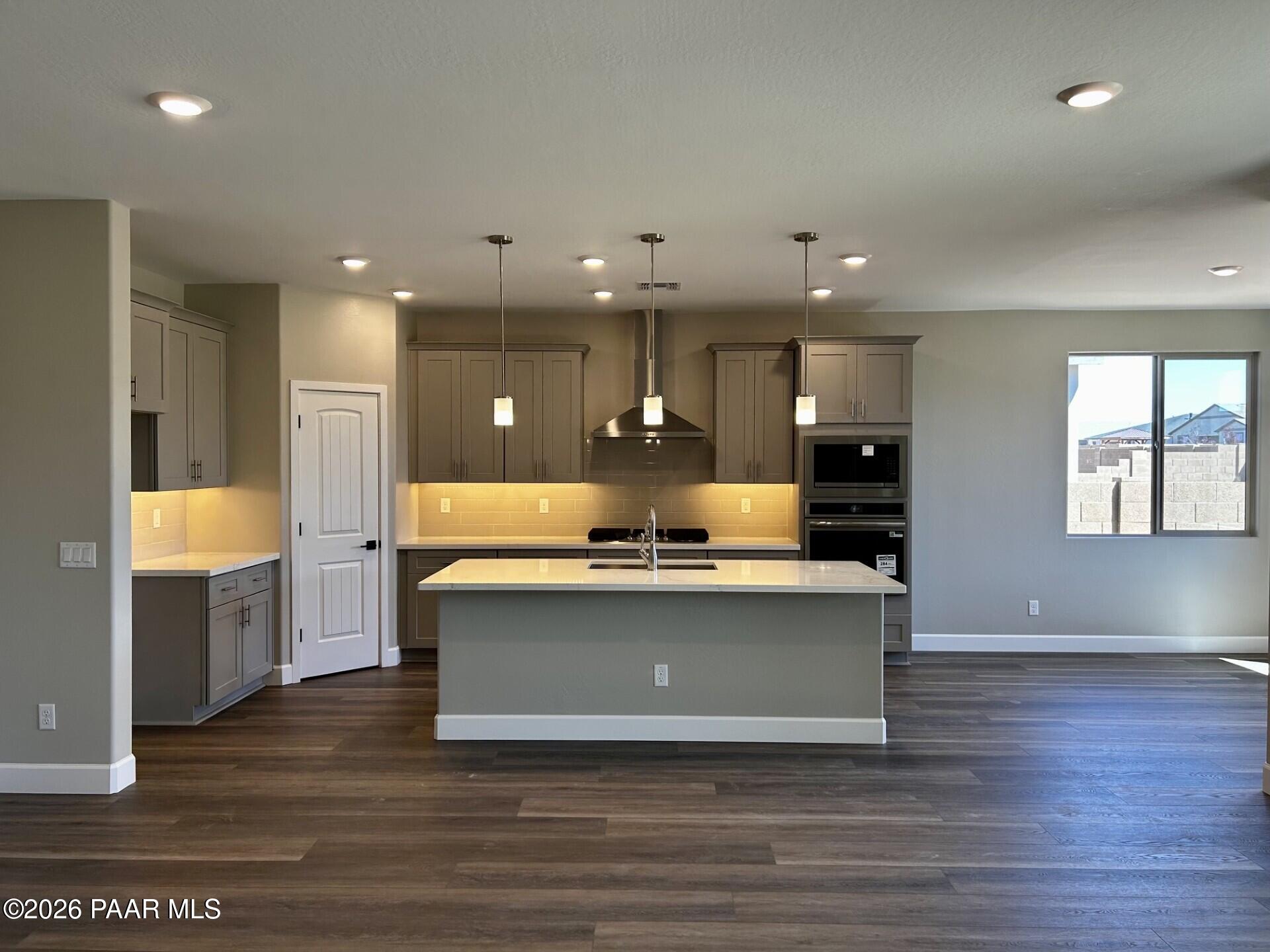 Modern kitchen with center island, gray cabinetry, and stainless appliances in The Harmony C floor plan, Prescott Valley.