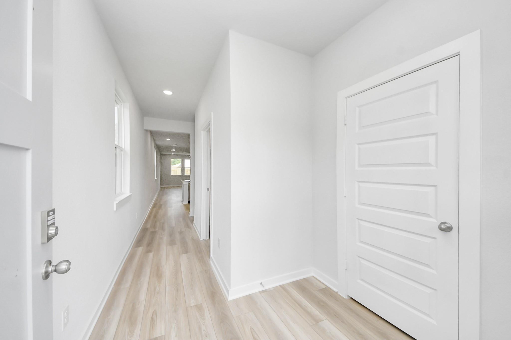 Bright foyer entryway with luxury vinyl plank flooring in The Sabine F floor plan by Davidson Homes, Cleveland, Texas.