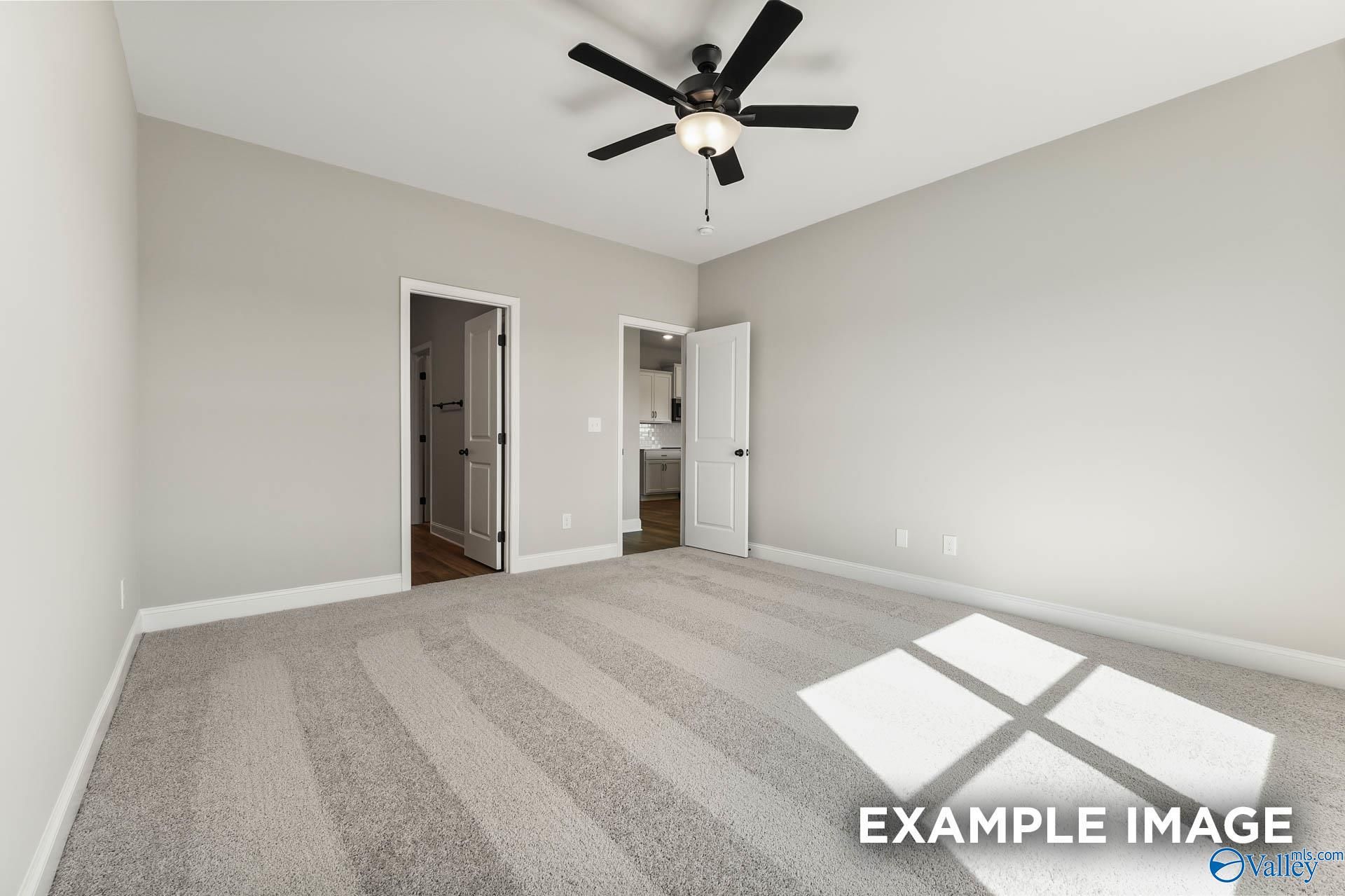 Spacious secondary bedroom with ceiling fan, beige walls, and en-suite bath access in Davidson Homes The Daphne C, Athens AL