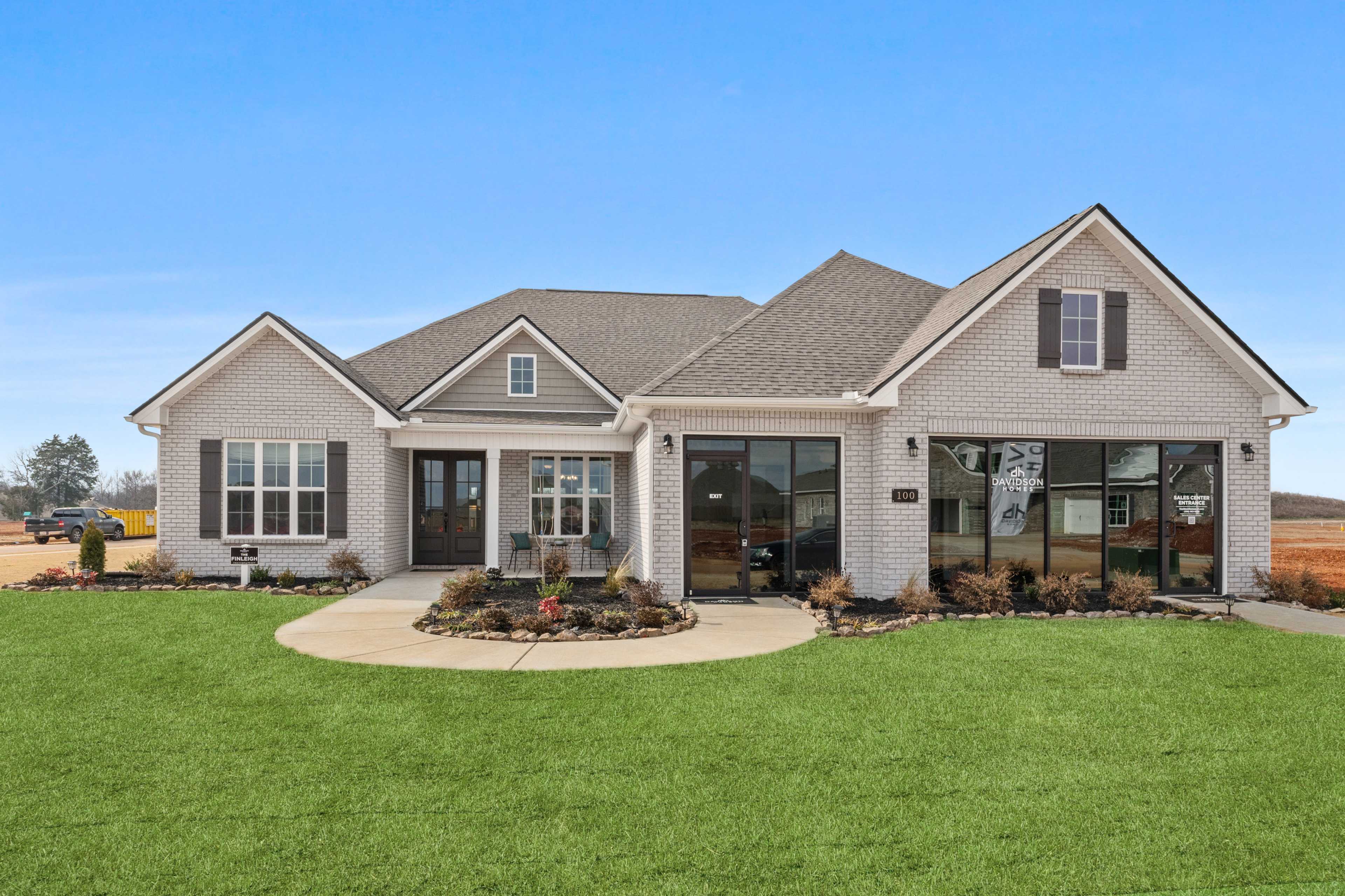 Contemporary ranch-style home exterior in Briercreek, Meridianville AL by Davidson Homes with brick accents, large windows, and landscaped lawn