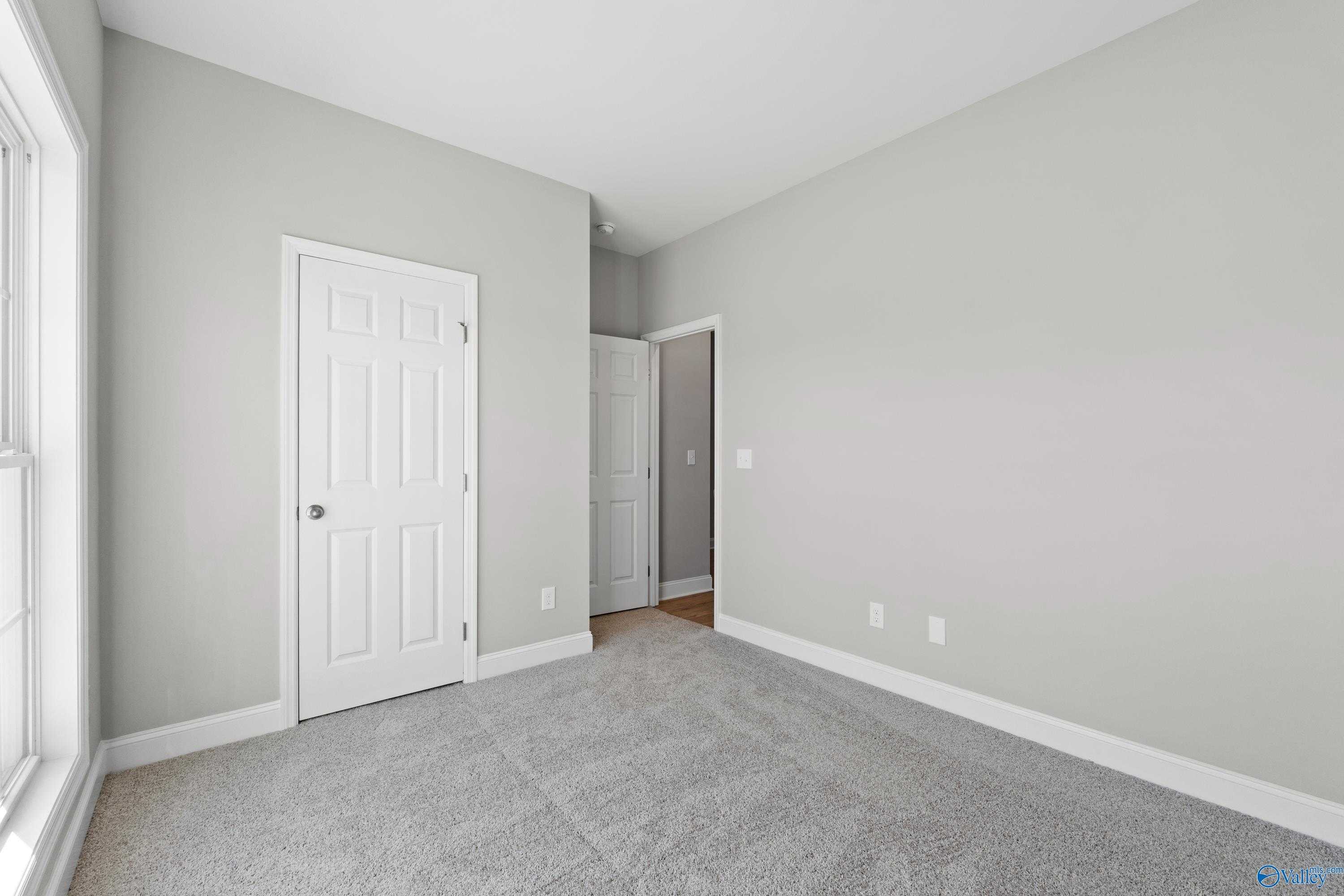 Bright secondary bedroom with gray walls, white doors, carpet floor in Davidson Homes The Asheville C, Athens AL