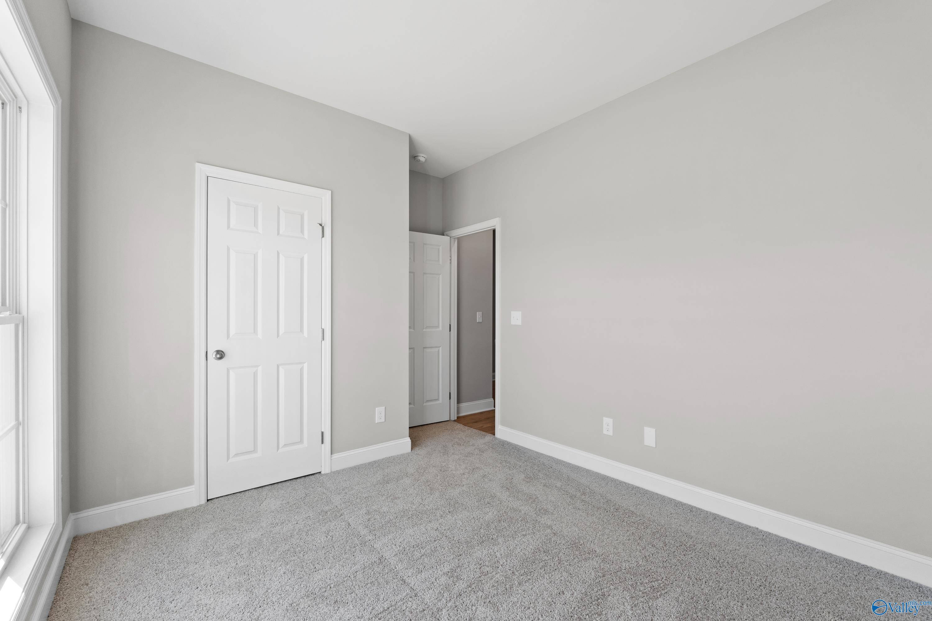 Bright secondary bedroom with gray walls, white doors, carpet floor in Davidson Homes The Asheville C, Athens AL