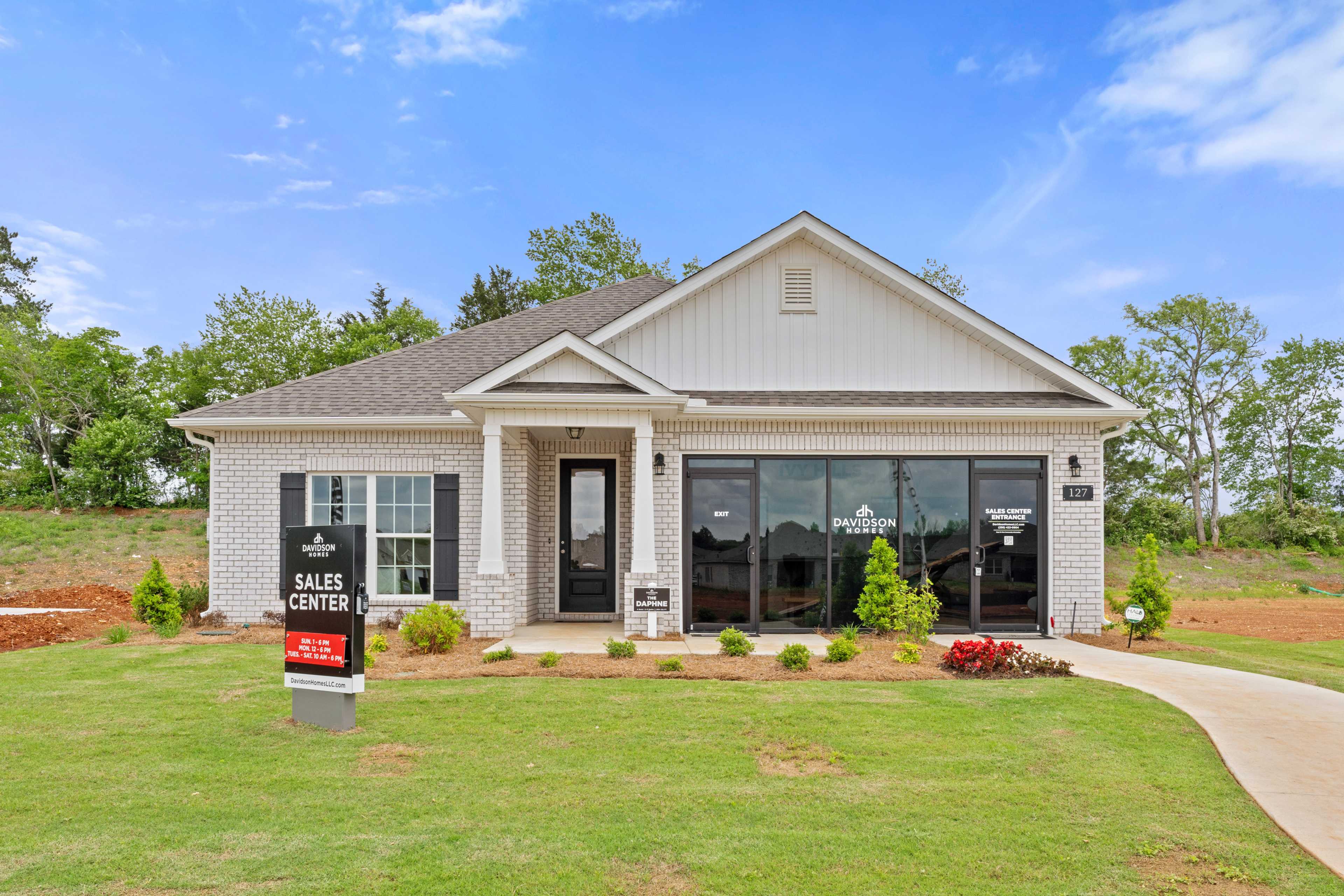 Modern sales center at Ivy Hills in Toney Alabama by Davidson Homes with brick accents large windows and landscaped yard