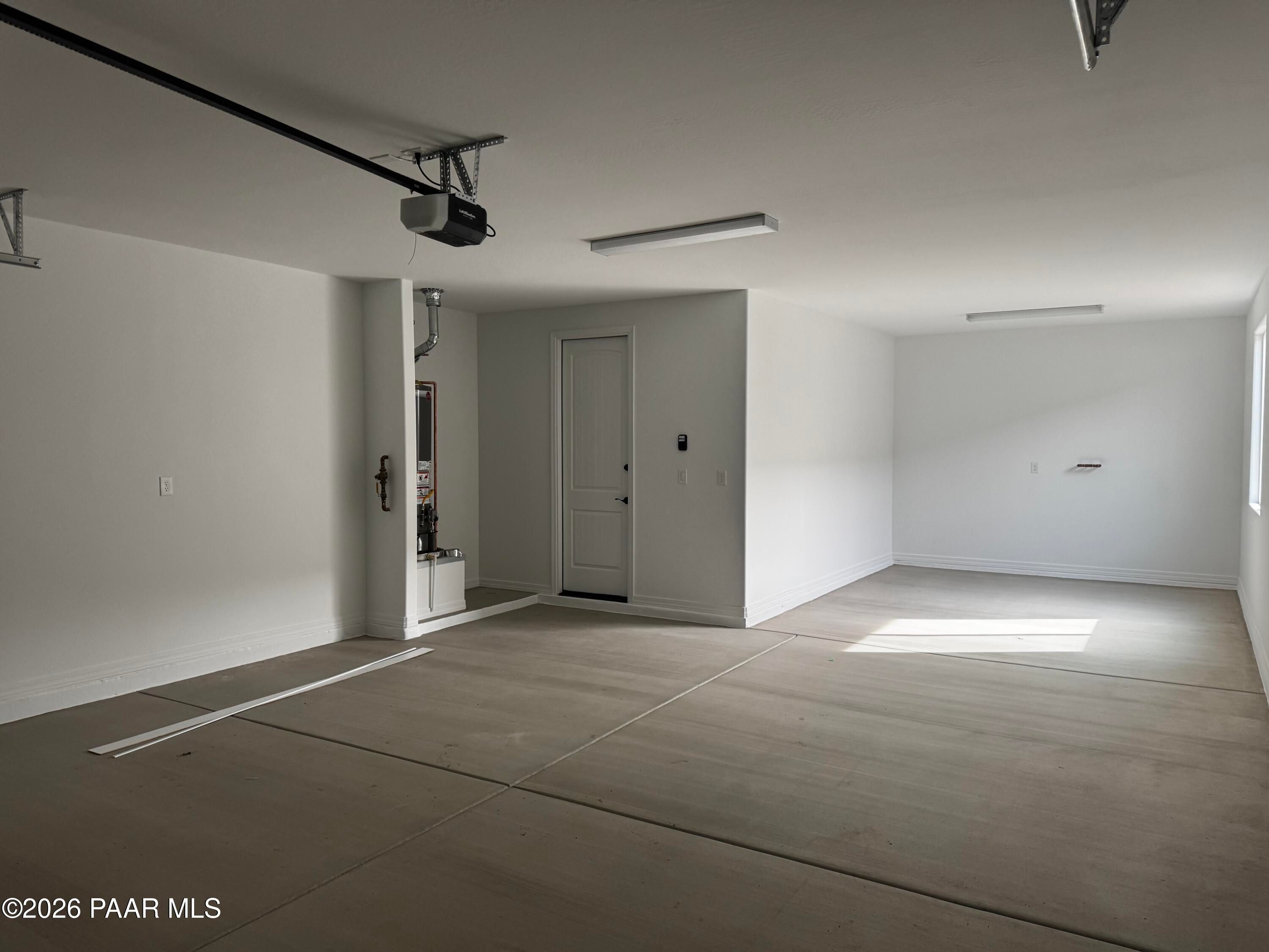 Spacious 3-car garage with polished concrete floors, overhead doors, and natural light in Davidson Homes The Durango II B, Prescott, Arizona