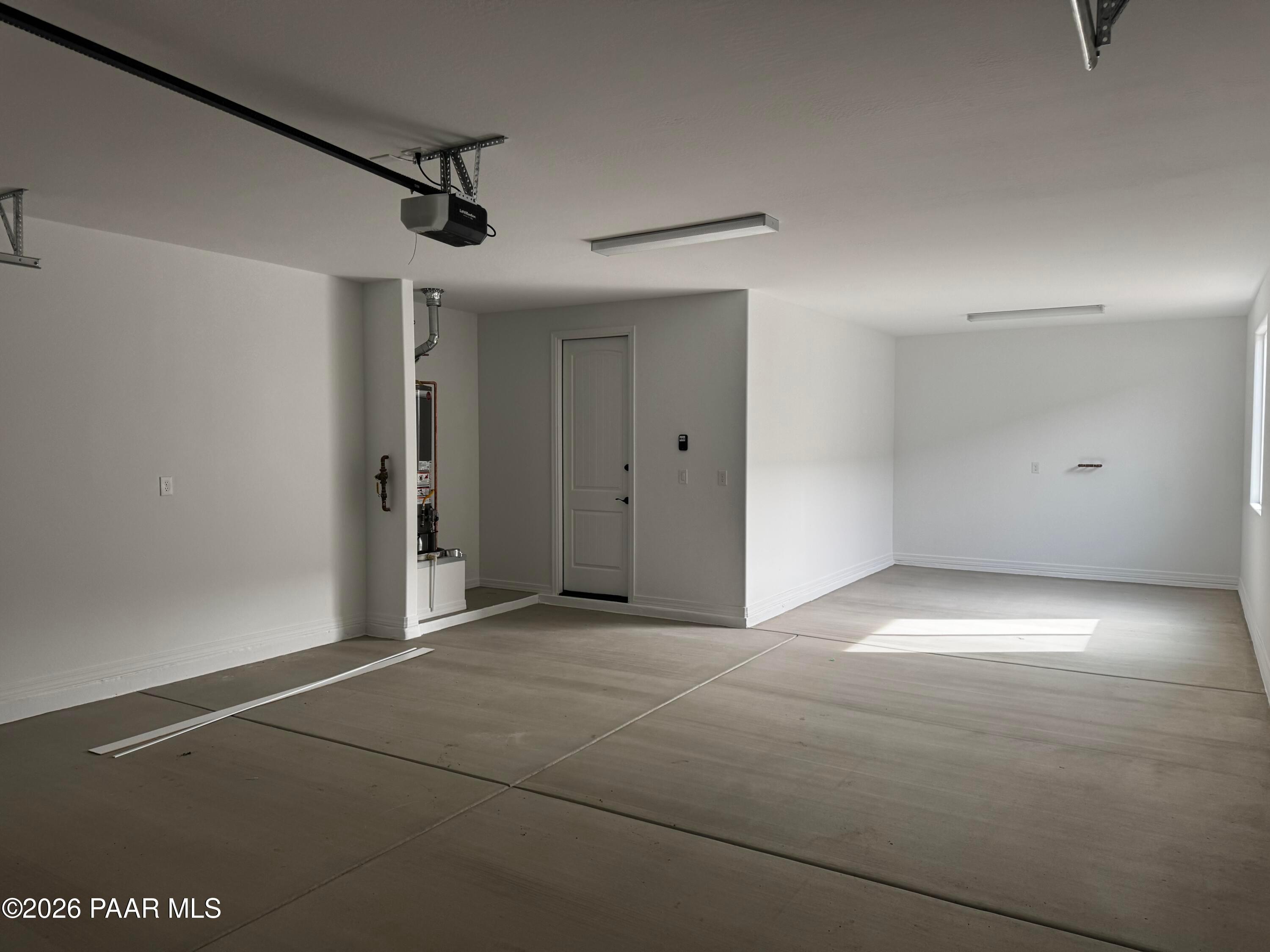 Spacious 3-car garage with polished concrete floors, overhead doors, and natural light in Davidson Homes The Durango II B, Prescott, Arizona