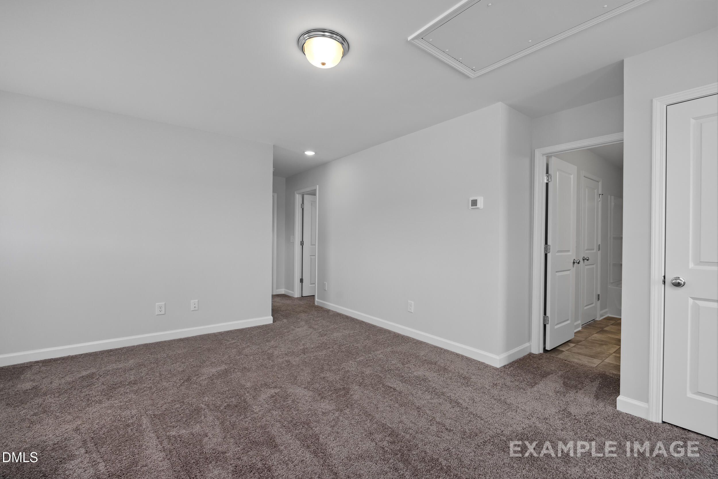 Spacious carpeted bedroom with white doors in The Gavin A floor plan by Davidson Homes at Gregory Village, Lillington, NC.