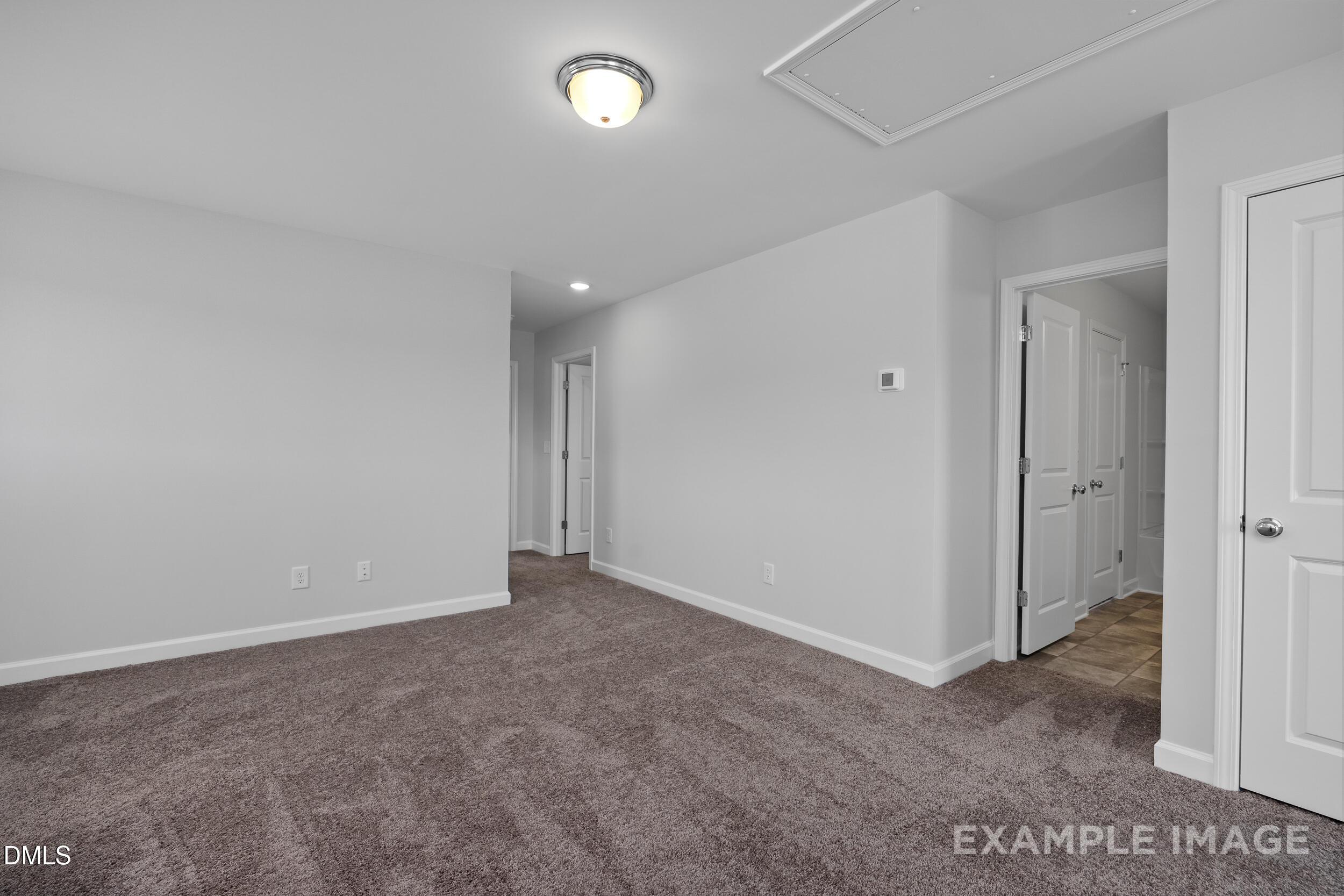 Spacious carpeted bedroom with white doors in The Gavin A floor plan by Davidson Homes at Gregory Village, Lillington, NC.