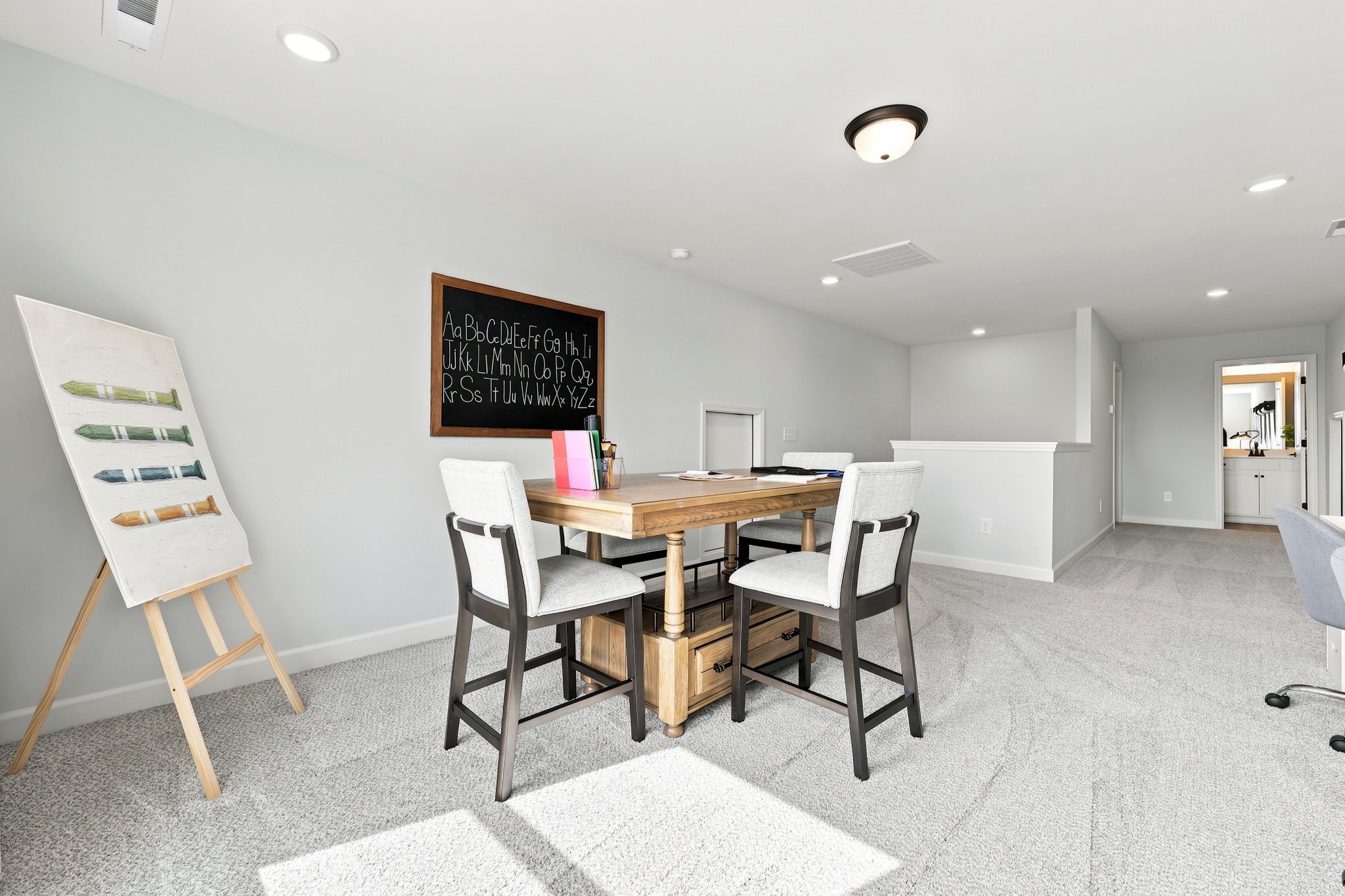 Spacious home office or playroom at Montrose in Aberdeen, NC by Davidson Homes featuring a study table and chalkboard decor.