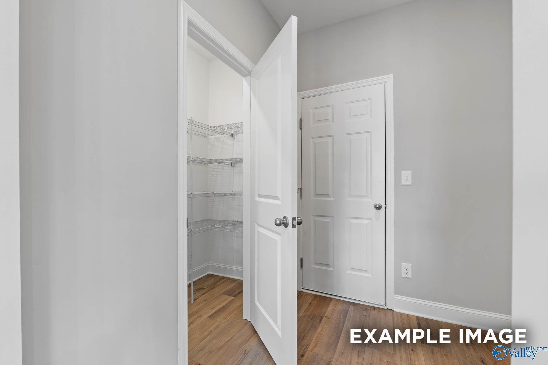Walk-in closet with wire shelving and hardwood-style flooring in Davidson Homes Chelsea B plan, Creek Grove, New Market, AL